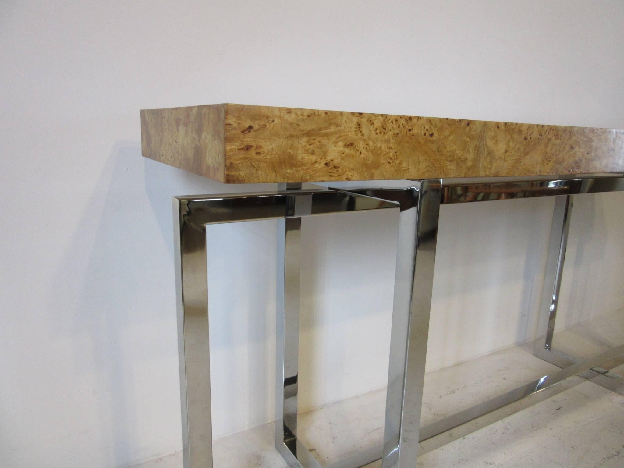 A chromed square tubed based console or sofa table with olivewood burl top ,the perfect size for that hard to fit location.
