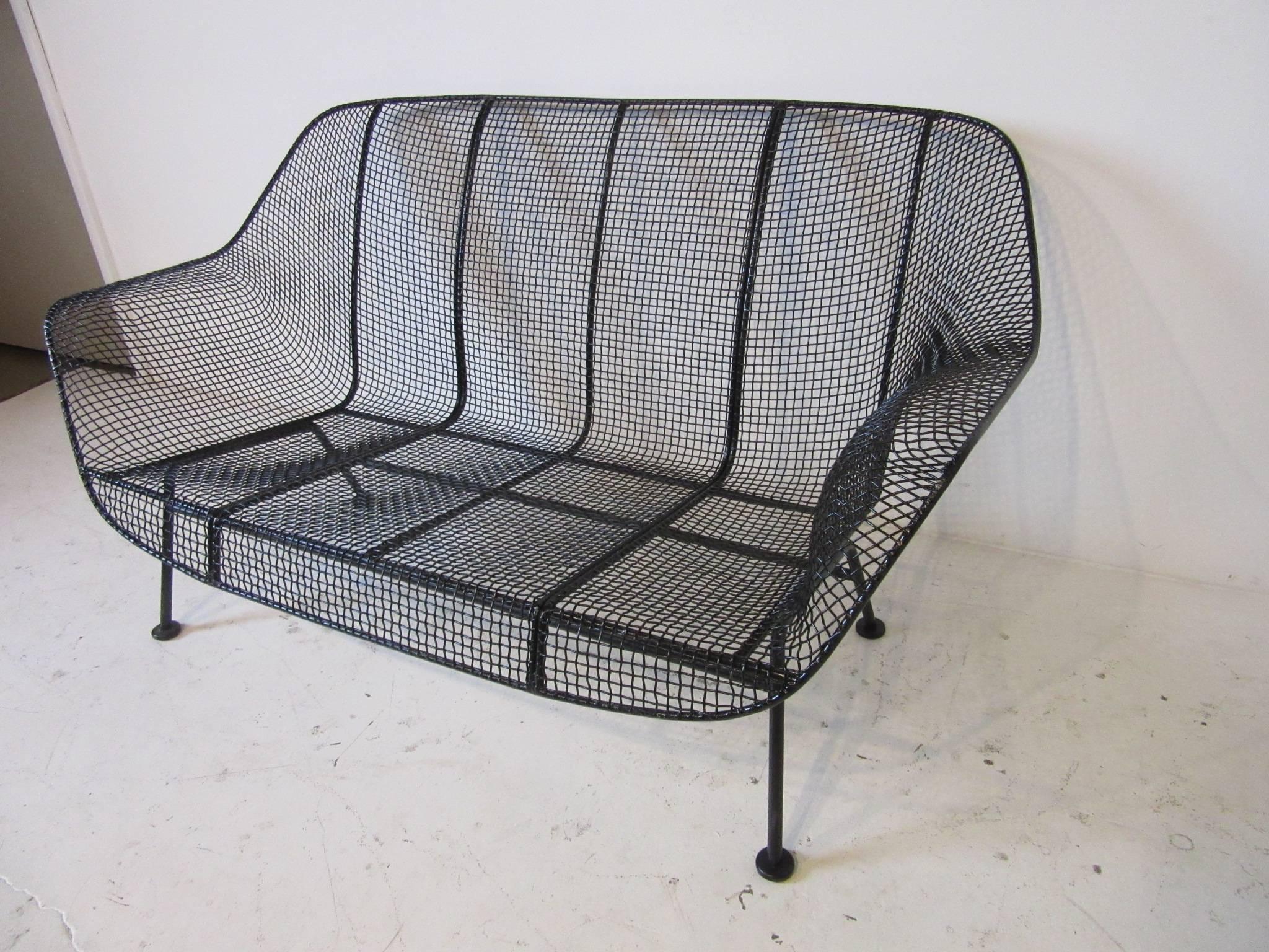 A welded and formed wire and iron loveseat by Russell Woodard from the Sculptura line, a Classic Mid-Century design for the deck, pool or garden. By the Woodard Furniture Company, Michigan.