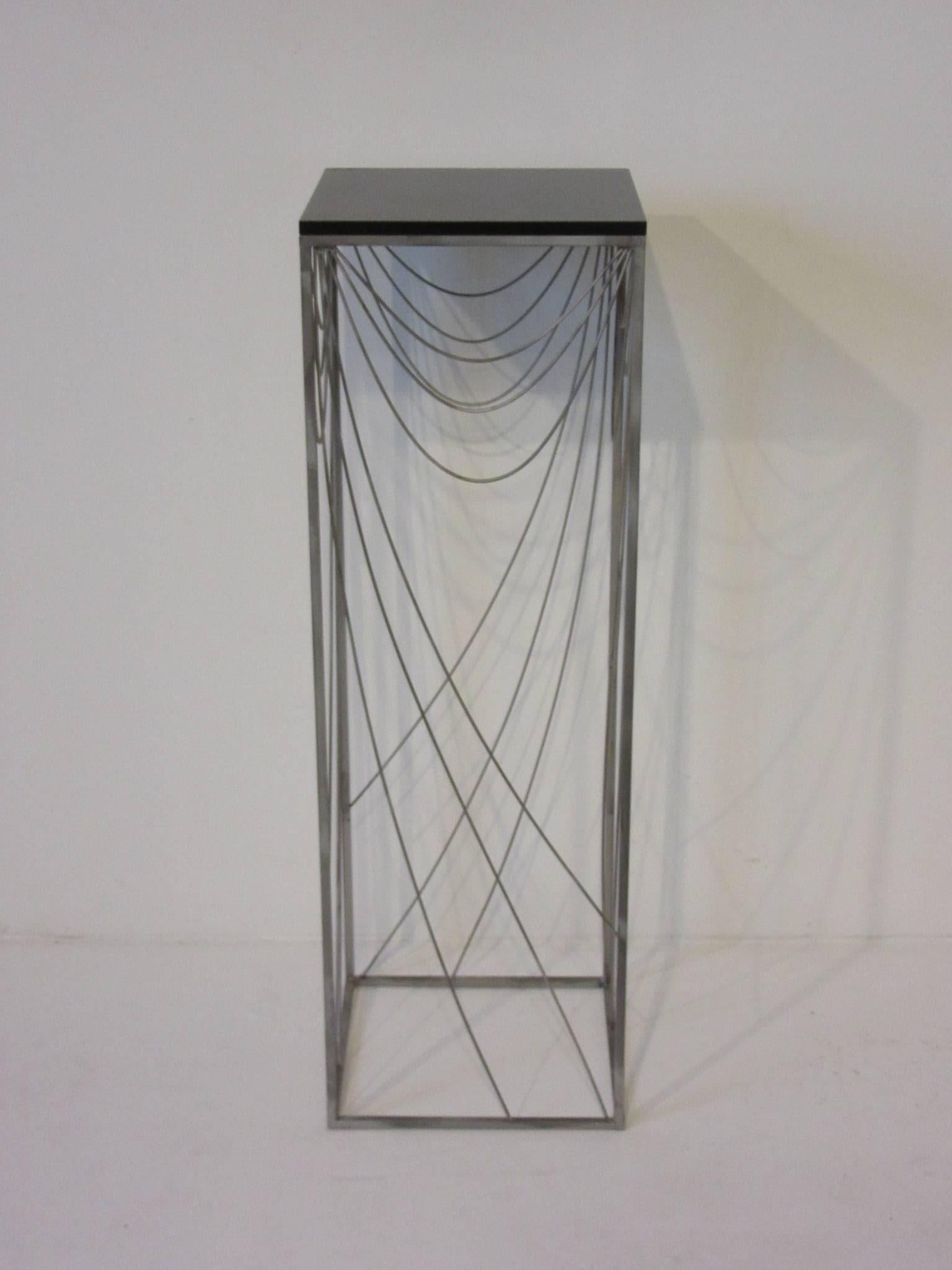 A light wispy spider web swag styled Jere pedestal with satin black wood top and sculptural steel frame design. Makes a statement but will not detract from the item displayed on its top platform. Two available.