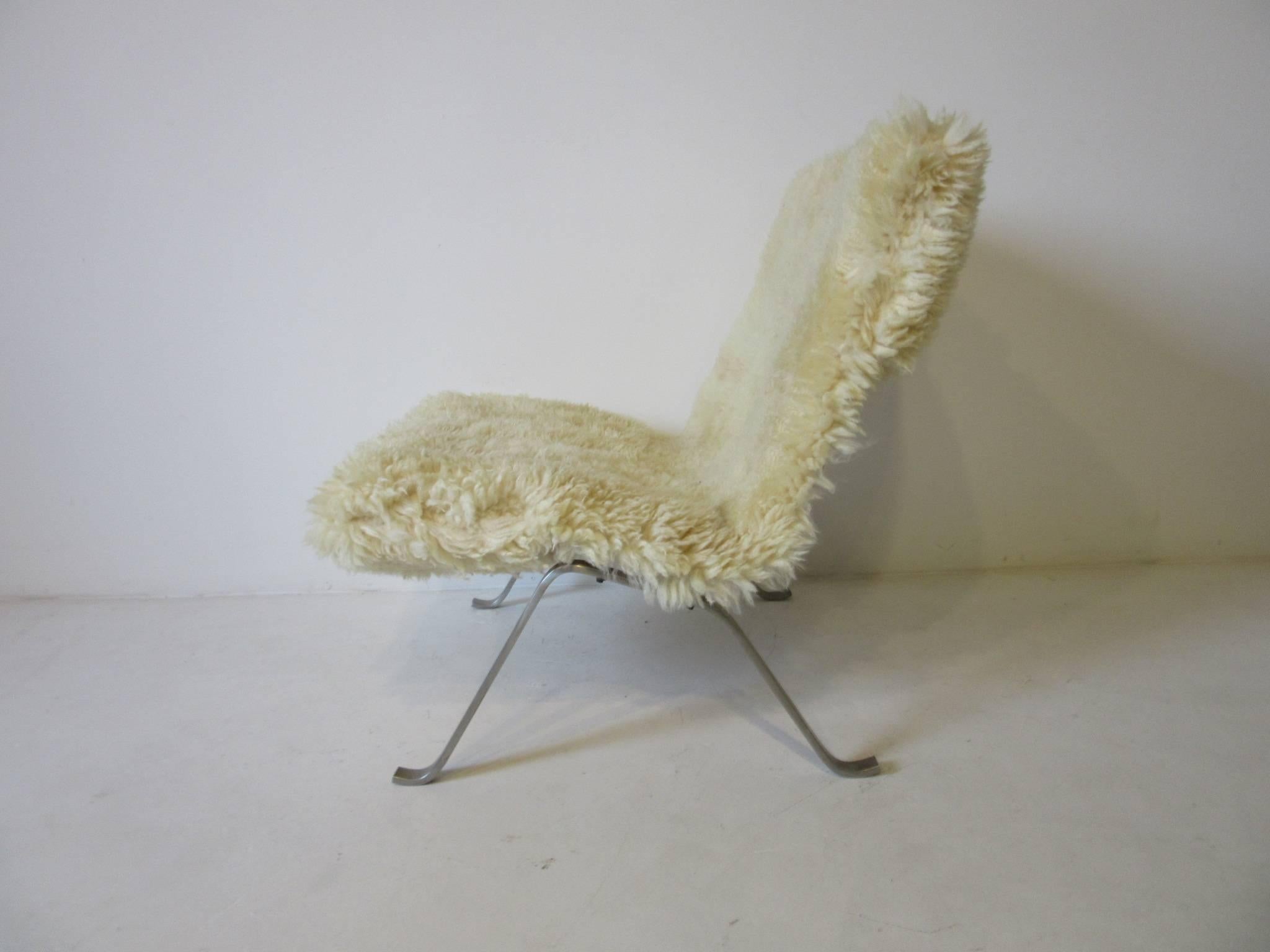 A Danish lounge chair with metal frame and woven seat covered in natural sheep skin designed by Poul Kjaerholm model number PK 22, a great Classic design.