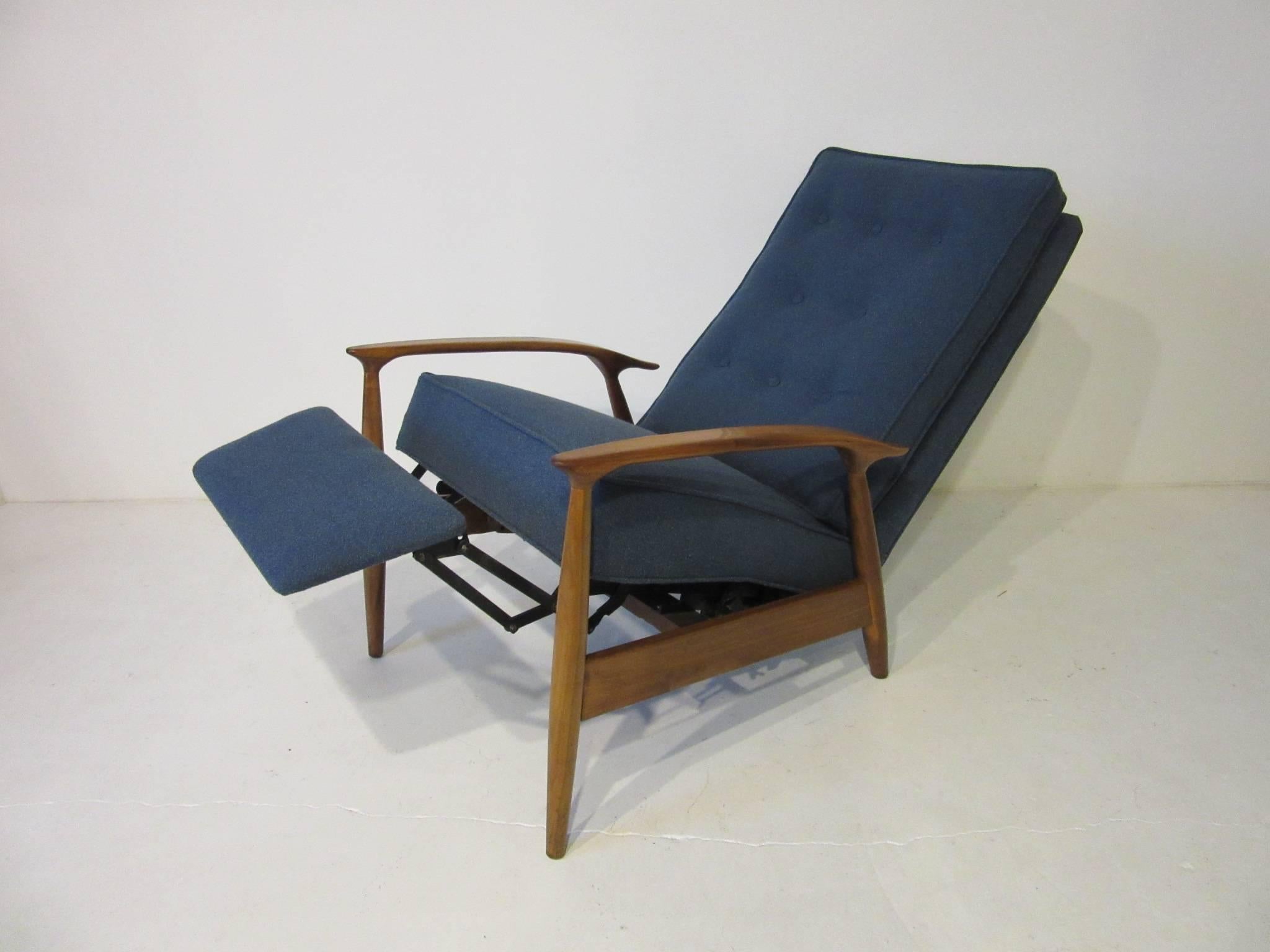 An early Milo Baughman recliner with footrest in a wool blend blue gray fabric, button back cushion and walnut frame. The chair reclines in two settings, half back and full lounge back with footrest. Manufactured by the Thayer Coggin furniture