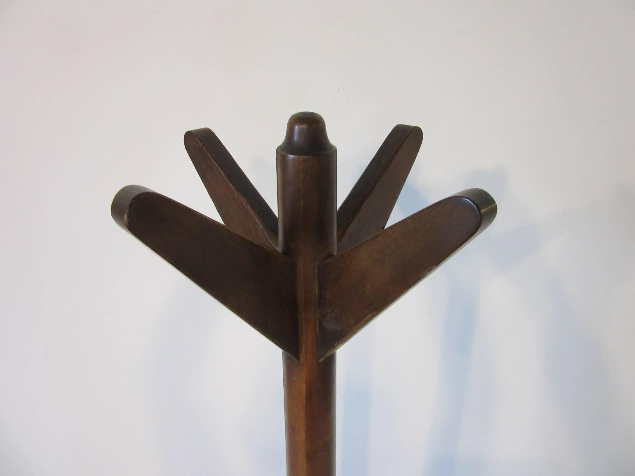 A rare wood and leather coat rack with wonderful lines designed by one of the best of his period Gilbert Rohde when he was chief designer for Herman Miller furniture company. Detailed top prongs, base in textured leather with metal stud detail, from