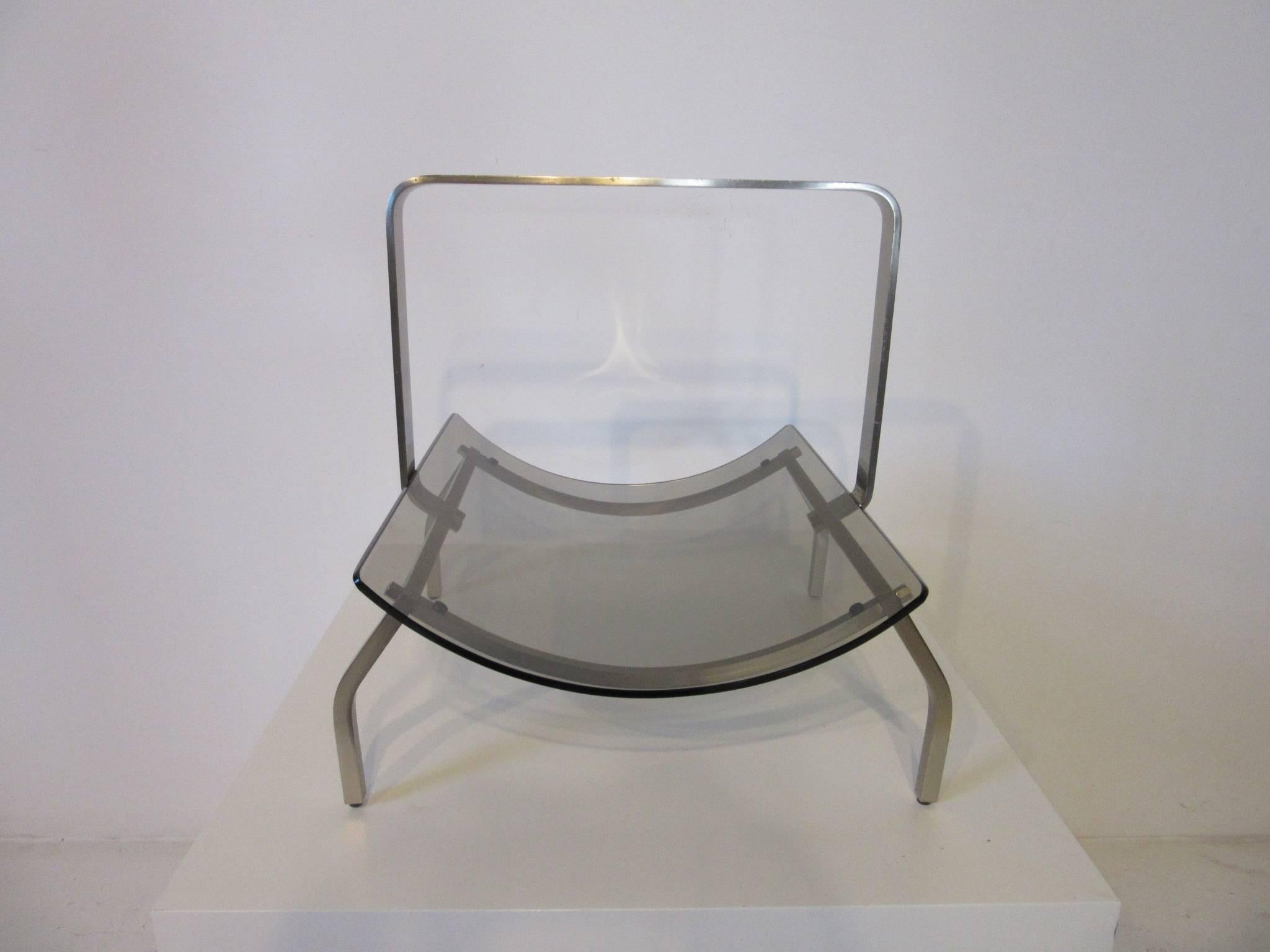 A stainless steel sculptural framed magazine rack with curved smoked glass insert made in Italy by Fontana Arte . A hard to find rare piece in that sleek light look and quality that is so much of the Italian design aesthetic . 