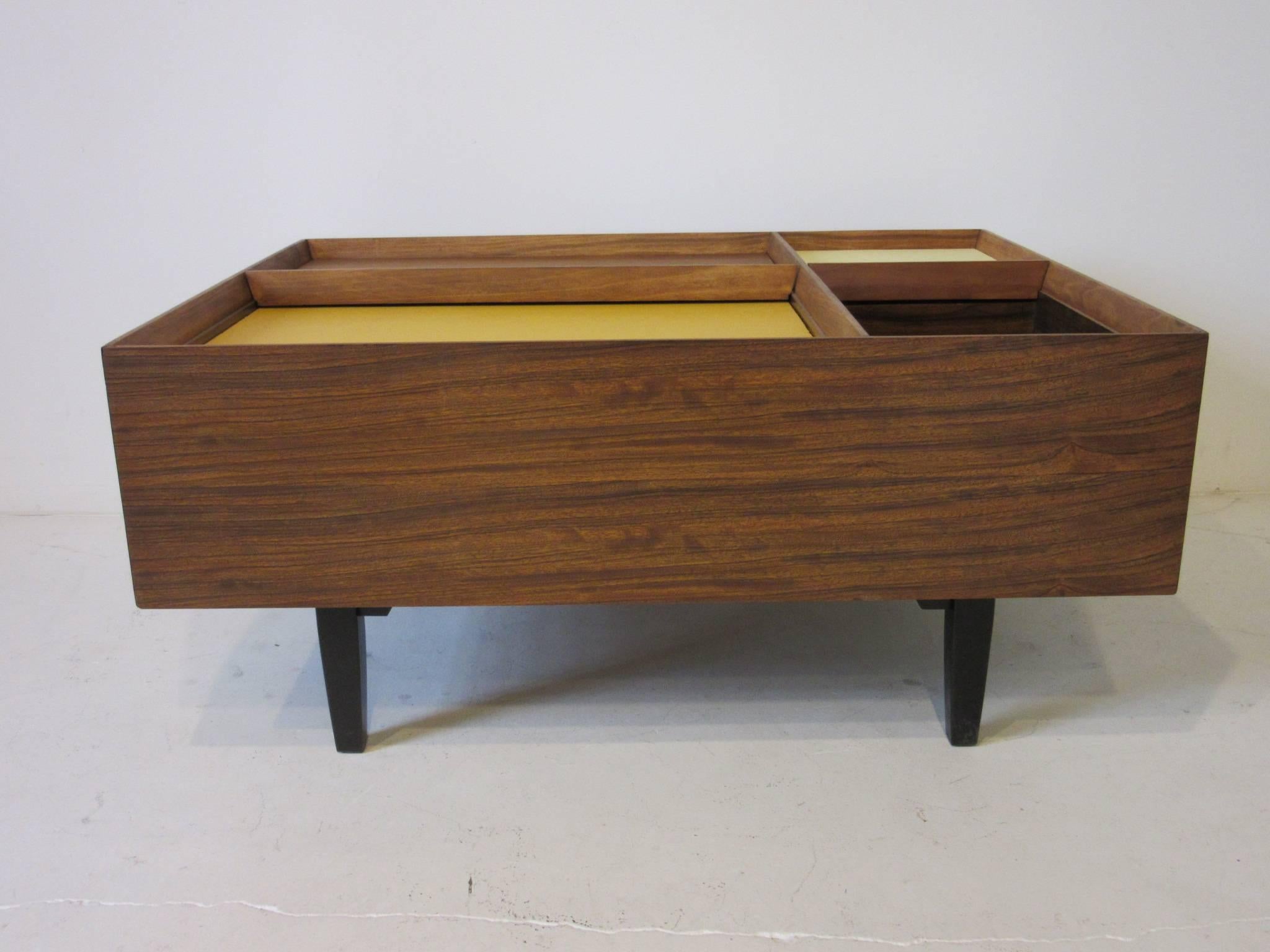 A very early coffee table by Milo Baughman using exotic Mindoro wood from the Philippines which is know for it's beautiful grain and shimmering affect. The three sliding upper doors reveling large storage bins and one open storage box. Manufactured