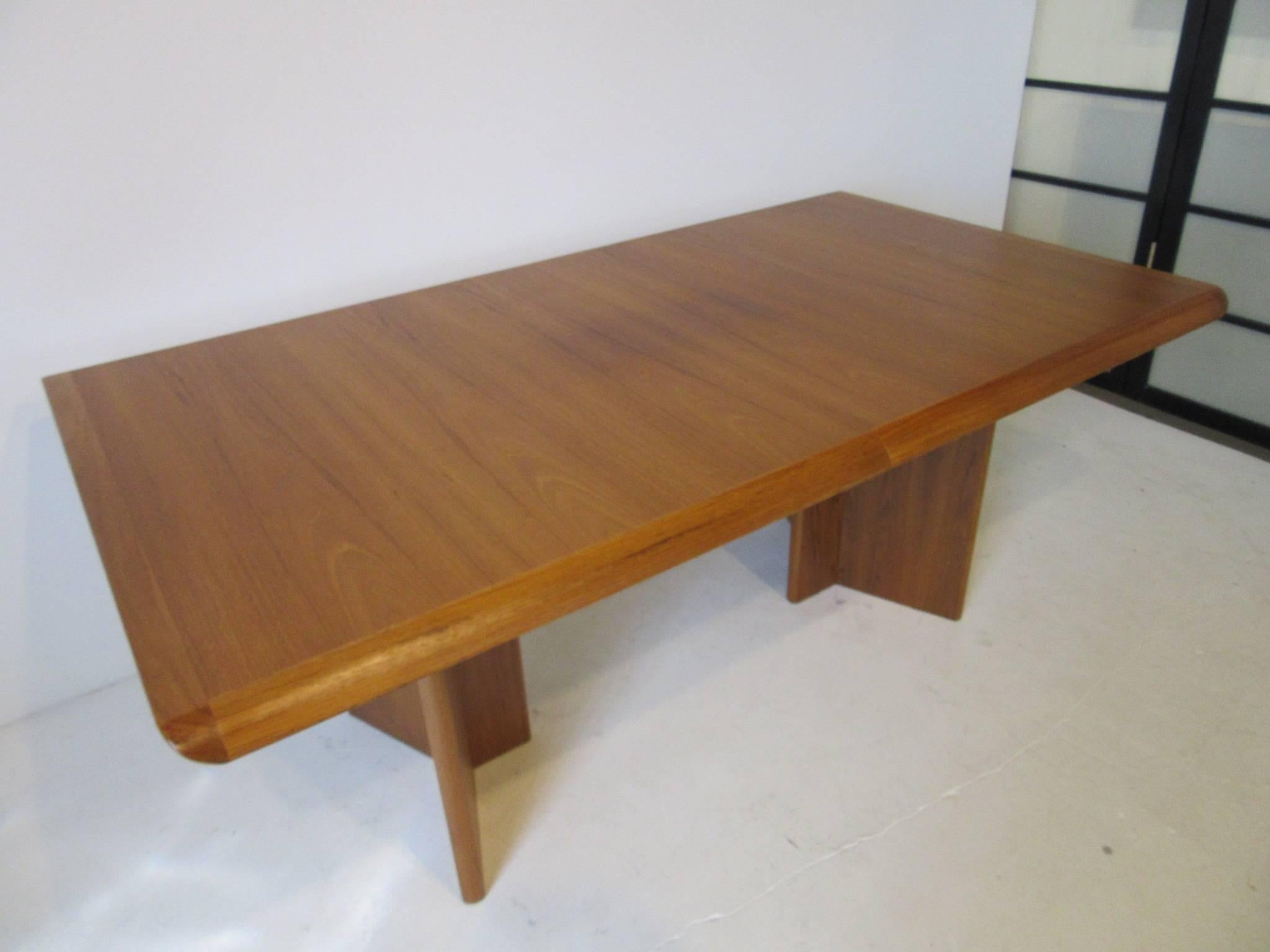 A well made teak wood dining or conference table with two 17.50
