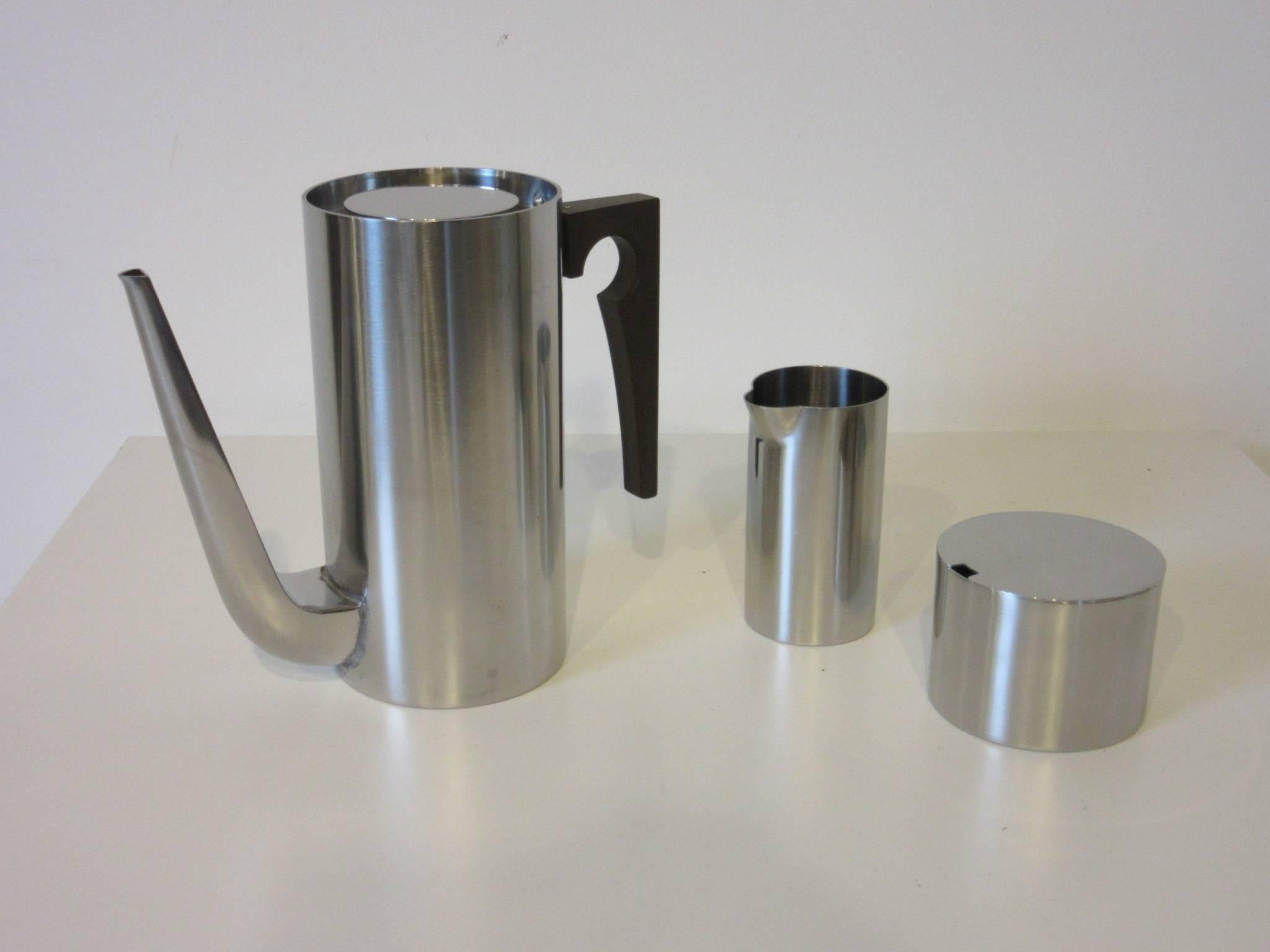 A four piece stainless steel coffee set with stylish serving tray, coffee pot, sugar container and creamer made in Denmark by Stelton.