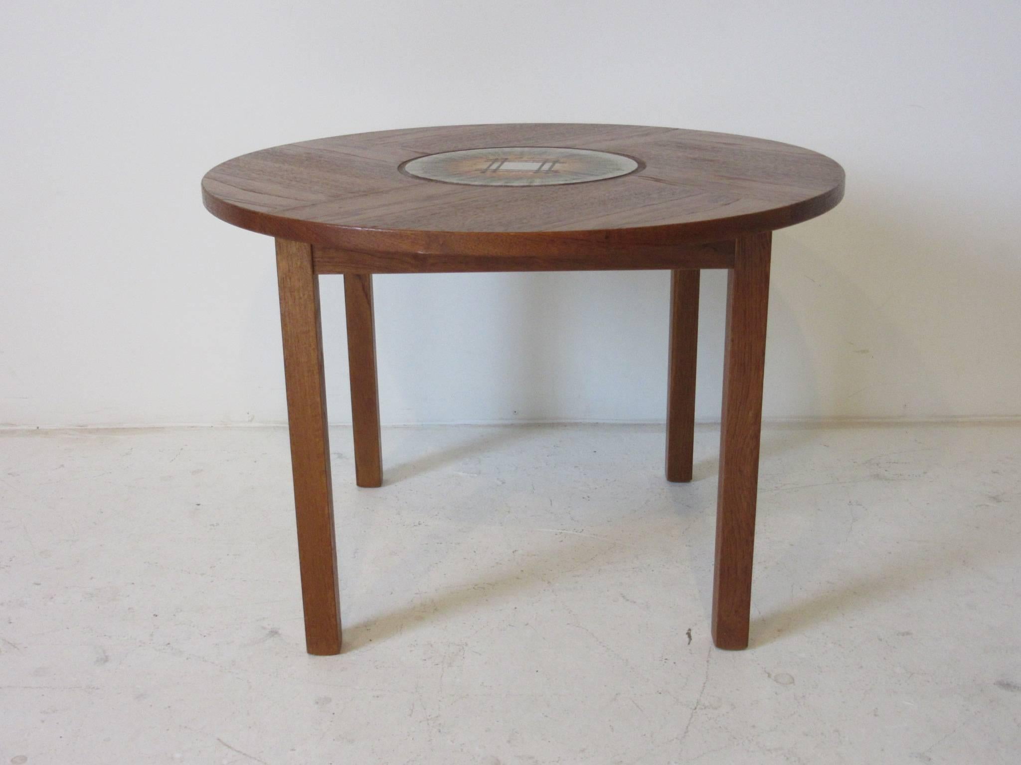 A teak wood side / end table with inlay handcrafted tile by artist and designer Tue Poulsen ink stamped to the bottom 