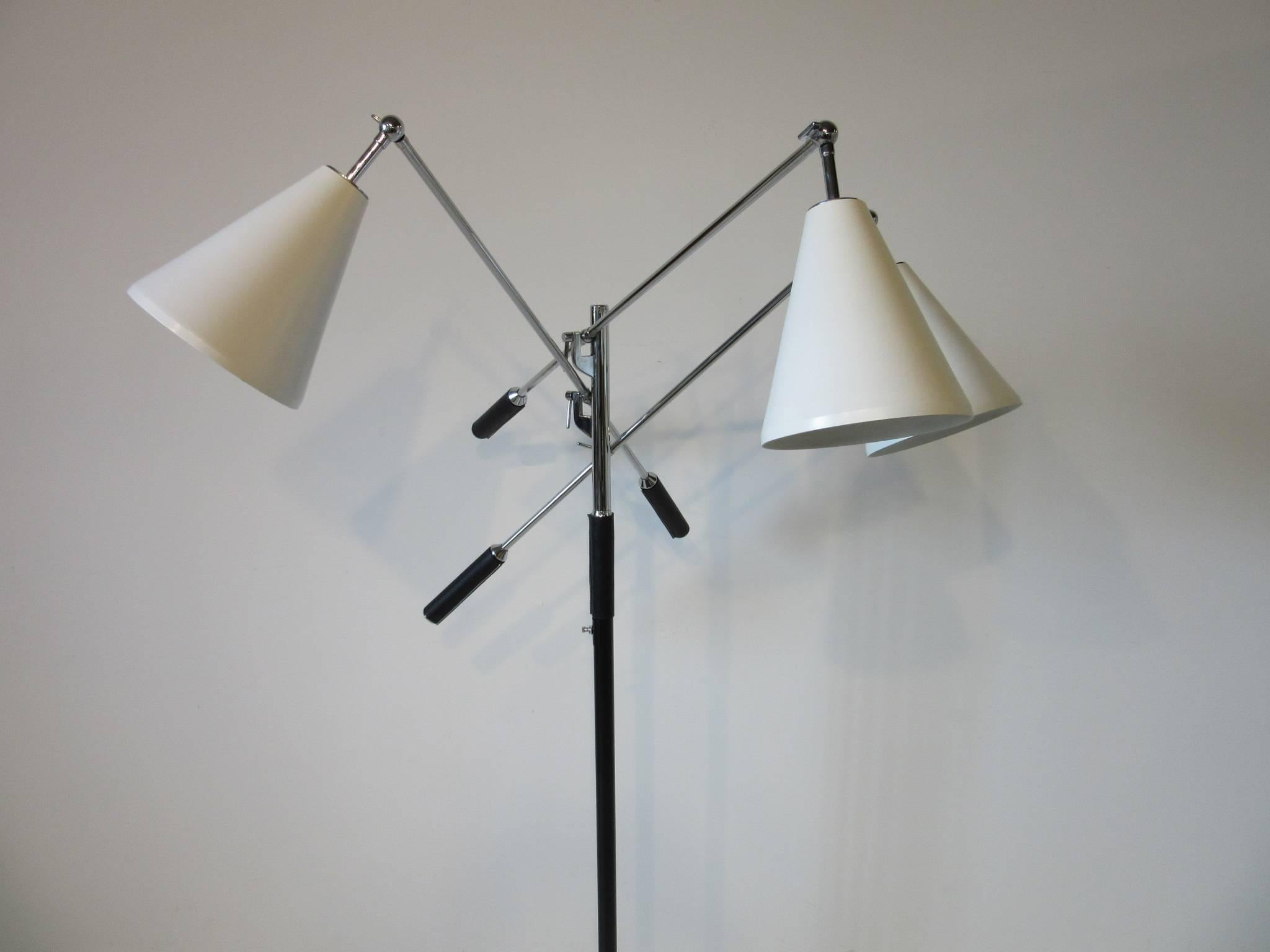 A three arm Triennale floor lamp with satin white cone shaped shades, chrome adjustable stems and staff with black leather handle covers. Having a three way light switch mounted on the pole all sitting on a round white Carrara marble base and is