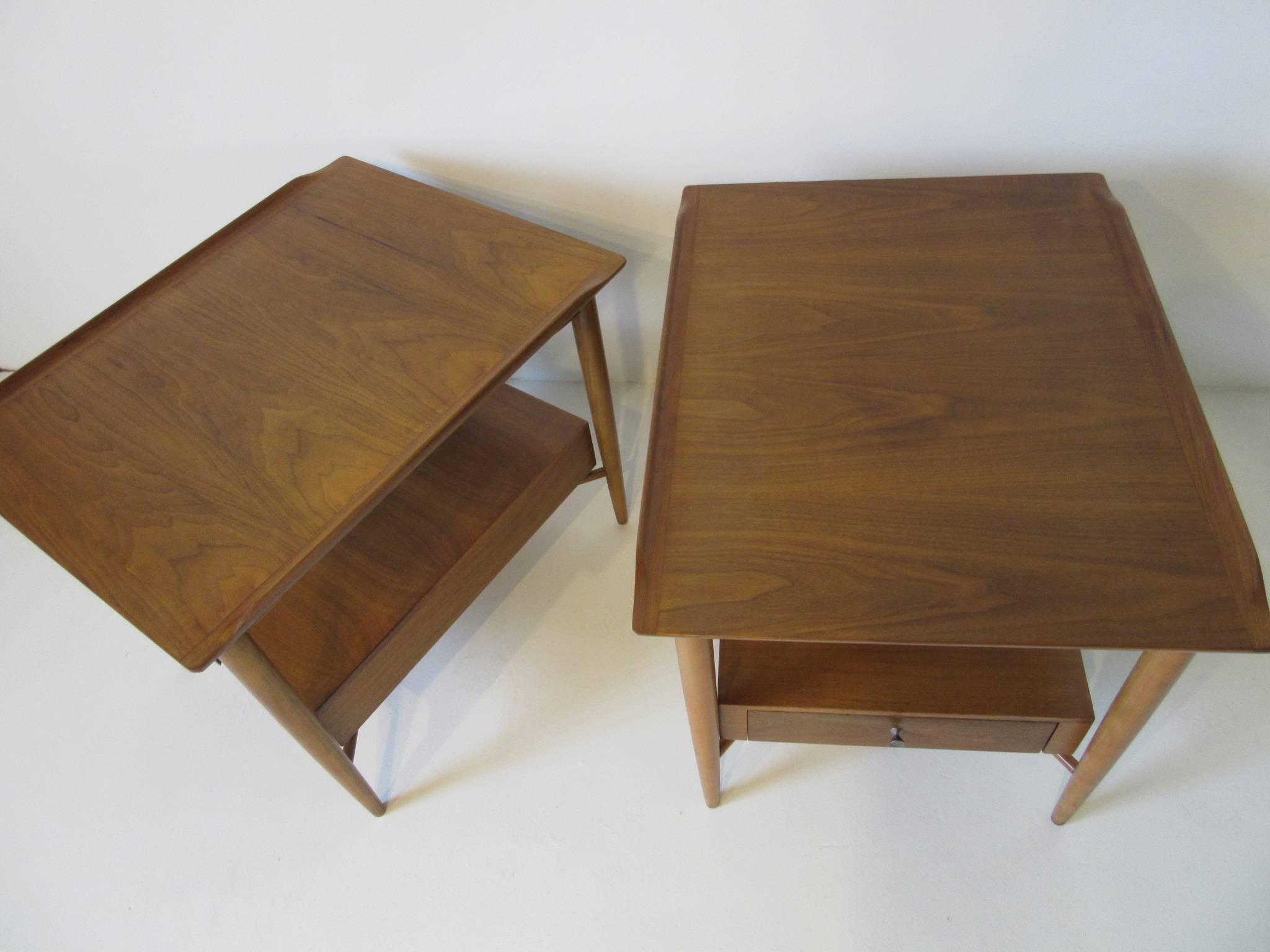 A pair of well grained mahogany end / side tables or nightstands with raised lip edge in the manner of Finn Juhl with single drawer and hourglass pull. The X-stretcher detail below the drawer gives it a floating and light look with coronal legs.