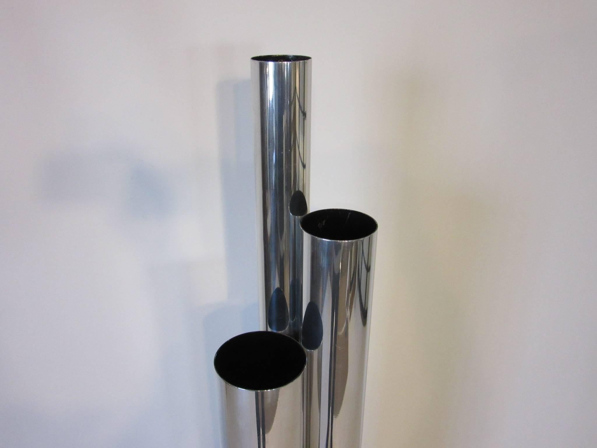 A anodized aluminium tubed floor or table lamp with polished tubes in three different heights hence the name Skyscraper or Stalagmite lamp with a foot controlled on and off switch.