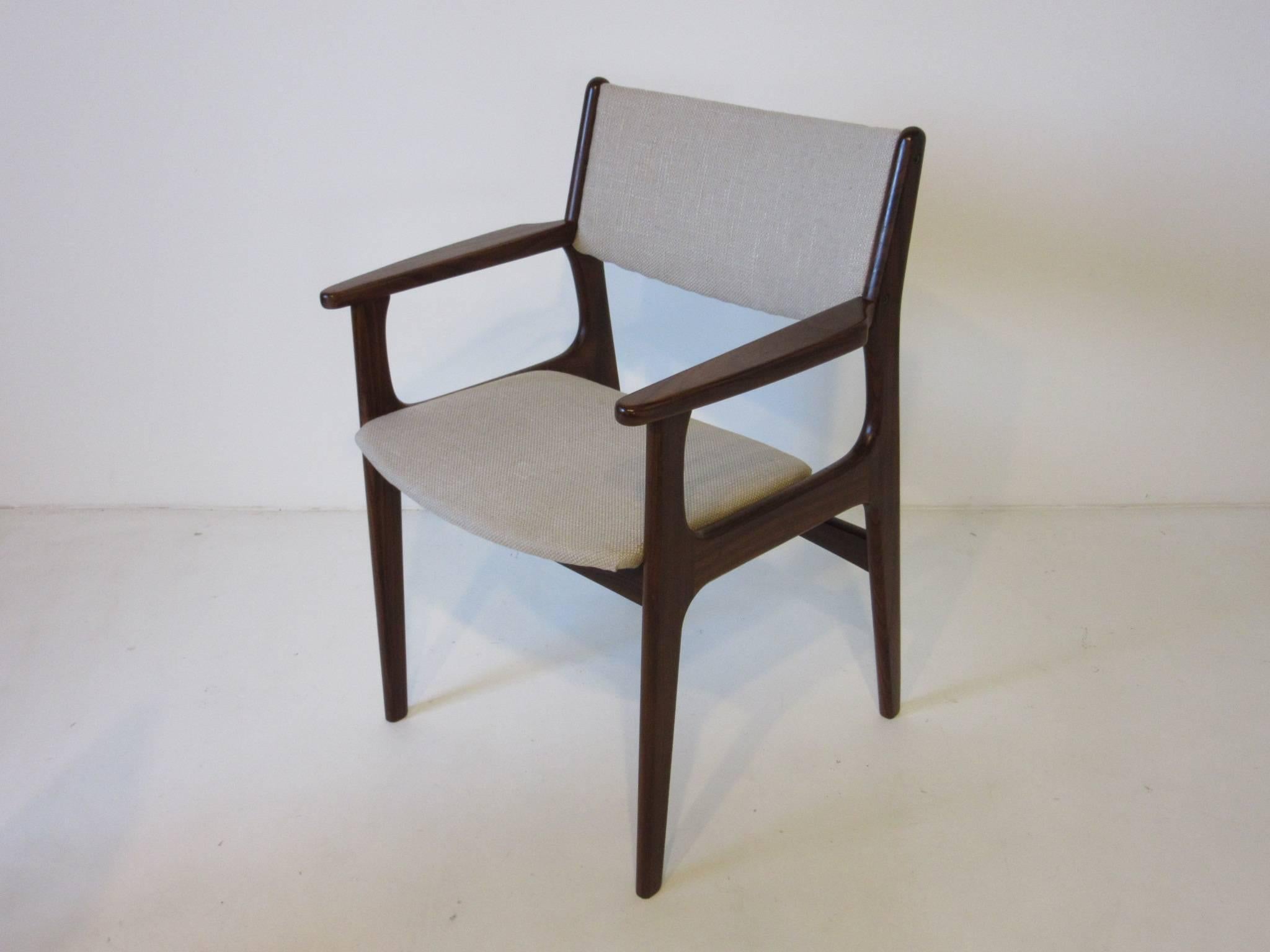 A set of four dark wood framed dining chairs with oatmeal toned fabric, two arm chairs and two side chairs complete the set, made in Denmark by Odense Mobel Fabrik. The side chair measurements are 19
