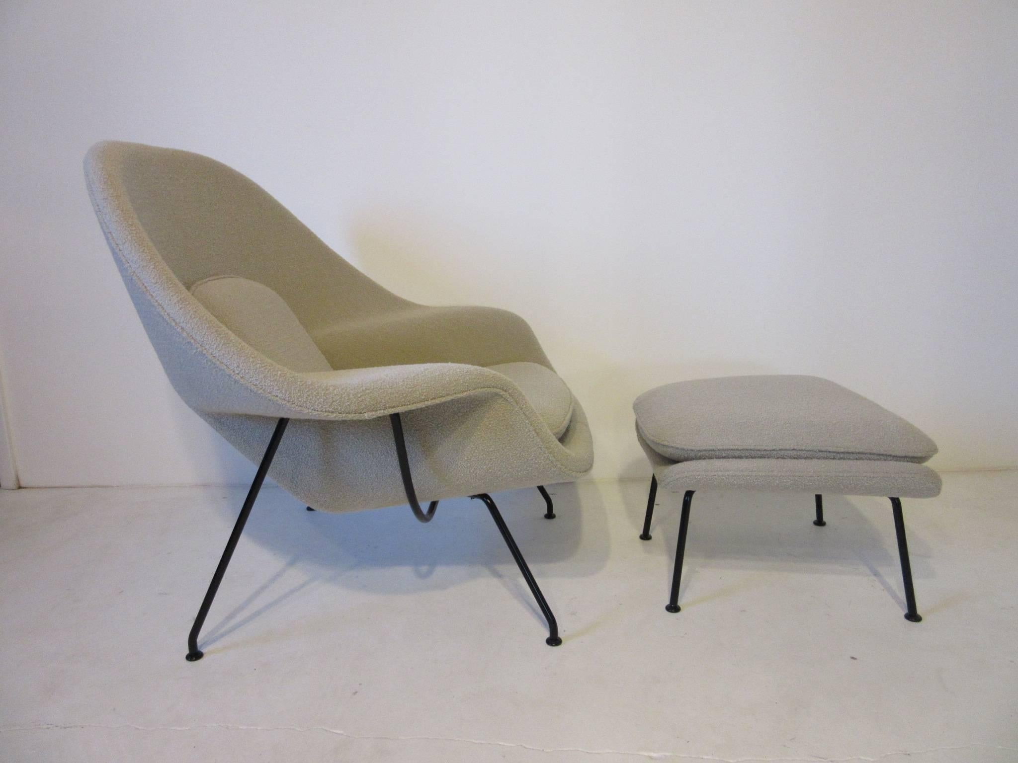 A wonderful Womb chair with matching ottoman in a nubby beige wool blend fabric with satin black sculptural metal frame. Retains the manufactures tag by the Knoll Furniture company a Classic design that still remains fresh. Ottoman measurement is