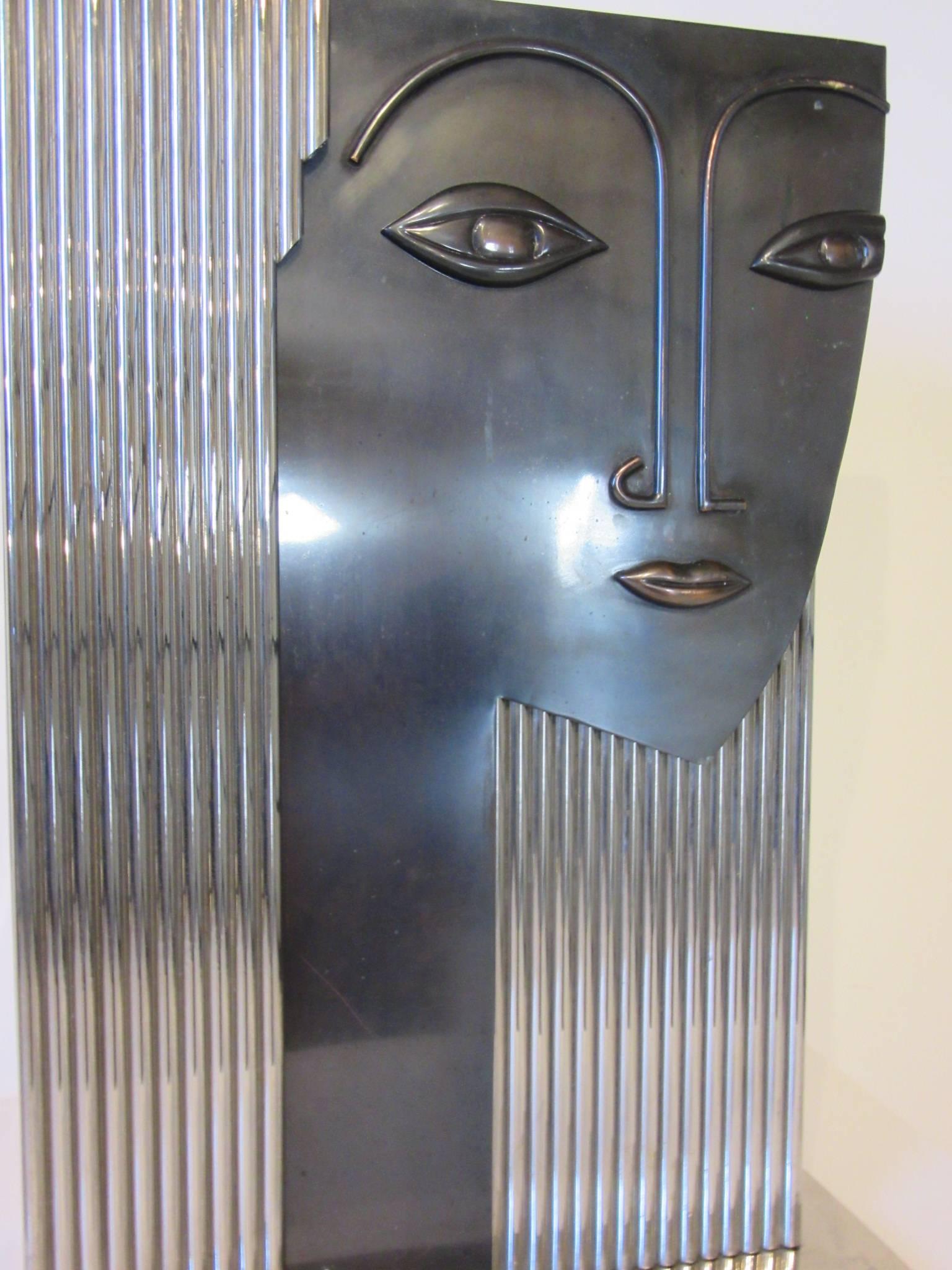 A large chromed and sculptured metal face vase sculpture with abstract features of a woman's head, squared base and upper opening. Unknown designer from the 1980s a well crafted piece that makes a statement.