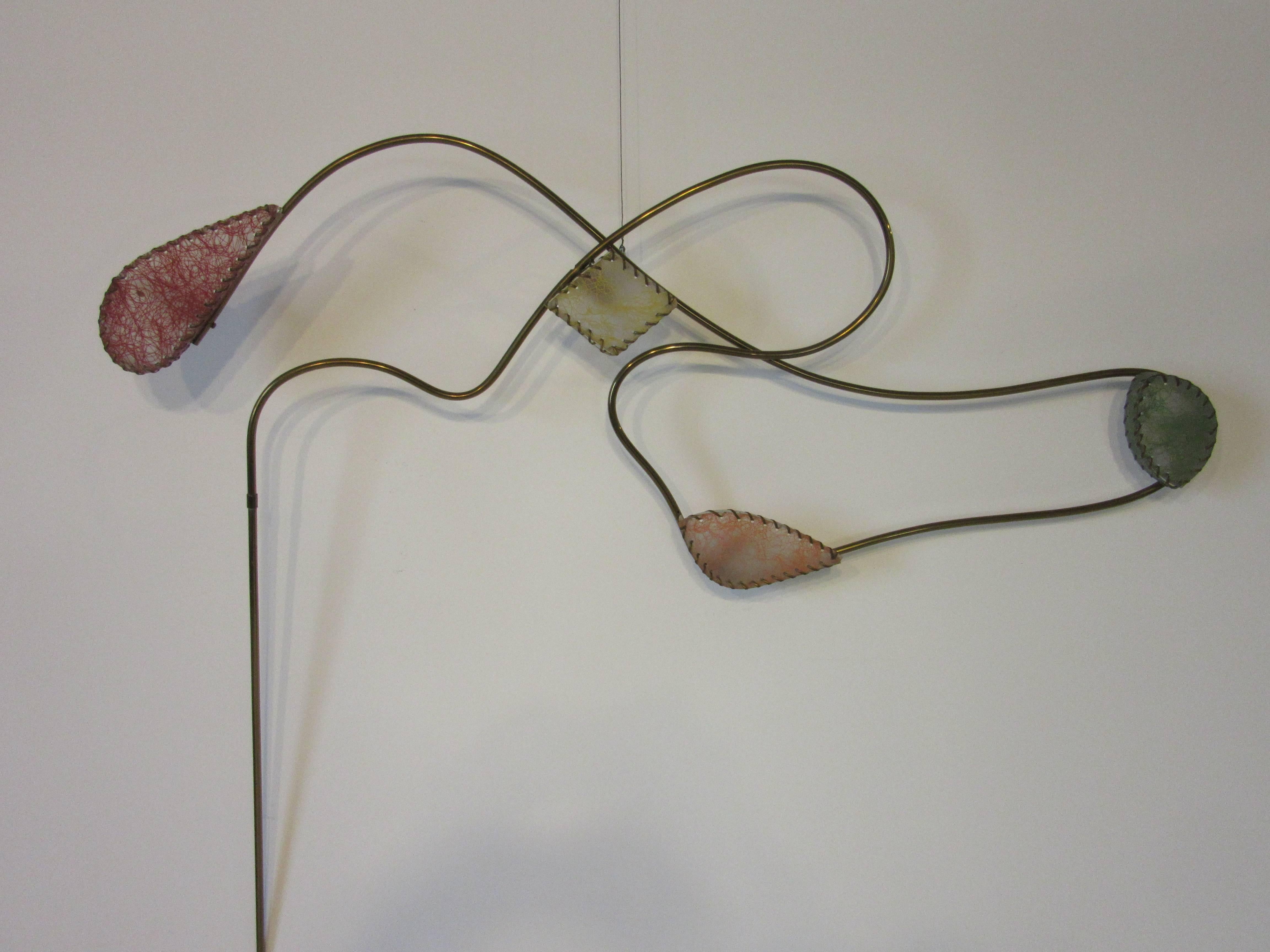 A rare brass bent tubed sculptural wall light with four fiberglass and thread formed shades in a very unique design from the 1950s by the Majestic Lamp Company. This manufacture was known for their Avant Garde styles and playfulness with unusual