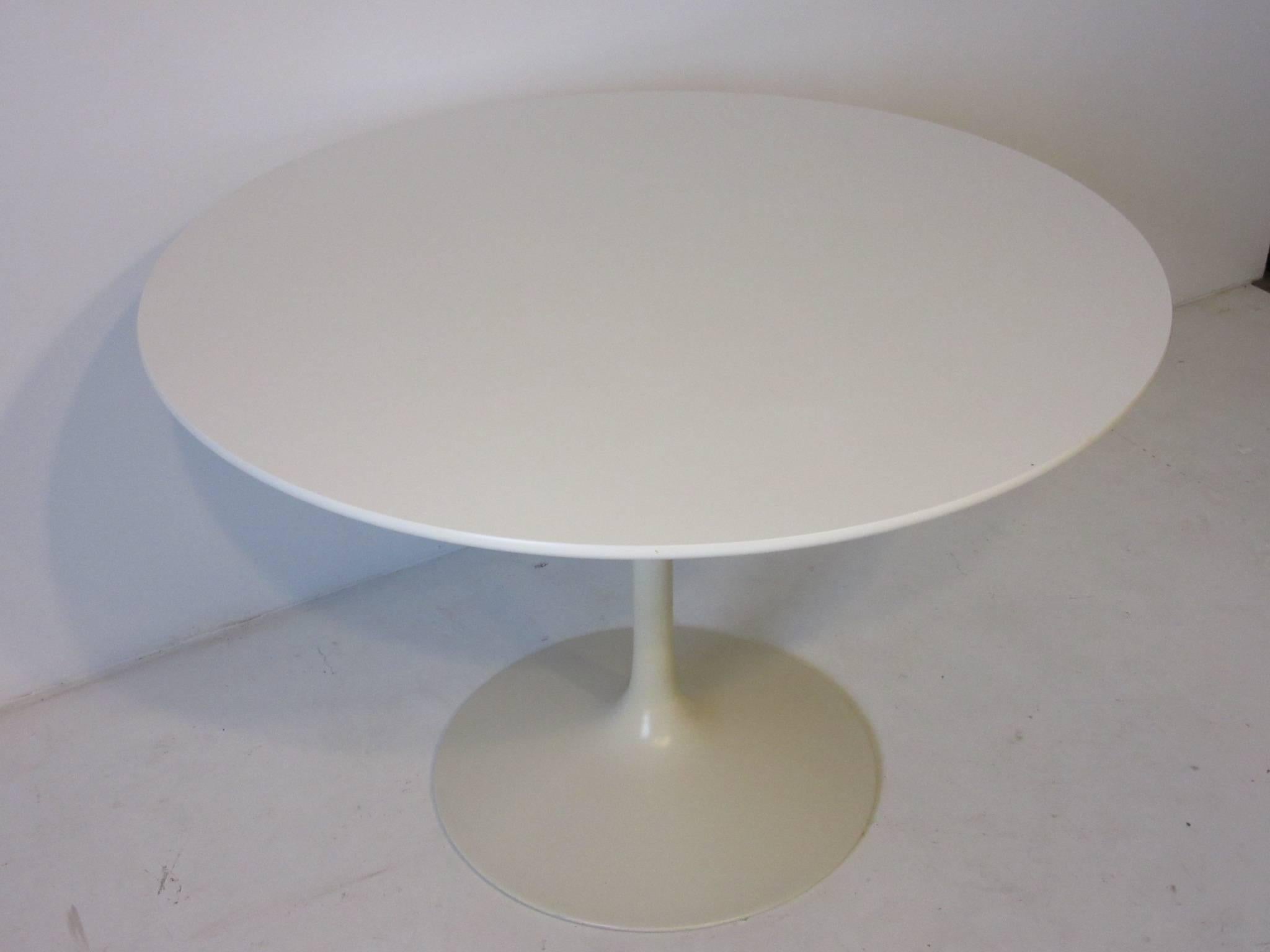 A white laminate topped tulip table with matching metal base manufactured by the Burke Furniture Company and designed by Maurice Burke. Perfect for that eat in kitchen or for that
office setting where you would need a smaller conference styled