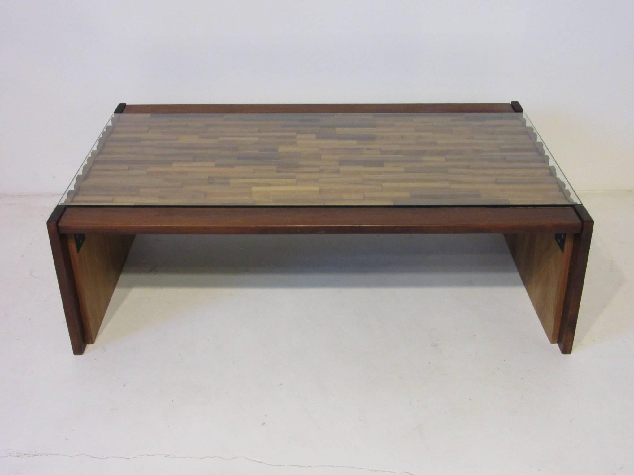A well constructed rich textured coffee table with form fitted pieces of rosewood topped with glass, also made with locking braces for folding flat. Designed by the noted artist Percival Lafer one of the top Brazilian furniture markers, Lafer MP