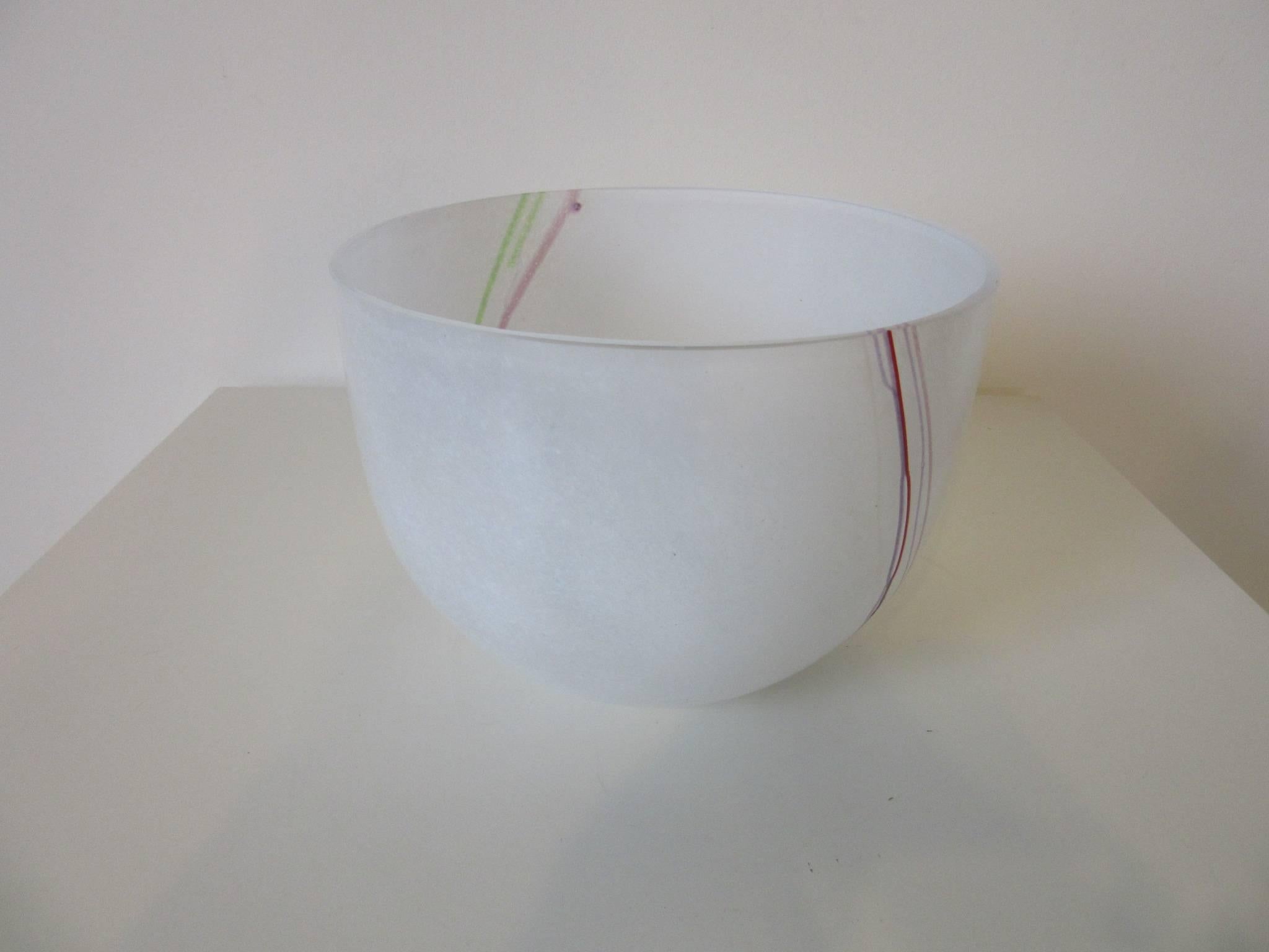 A large handcrafted decorative glass bowl with multicolored strands of glass to the sides, designed and made by Bertil Vallien for Kosta Boda. Etched to the bottom of the piece 