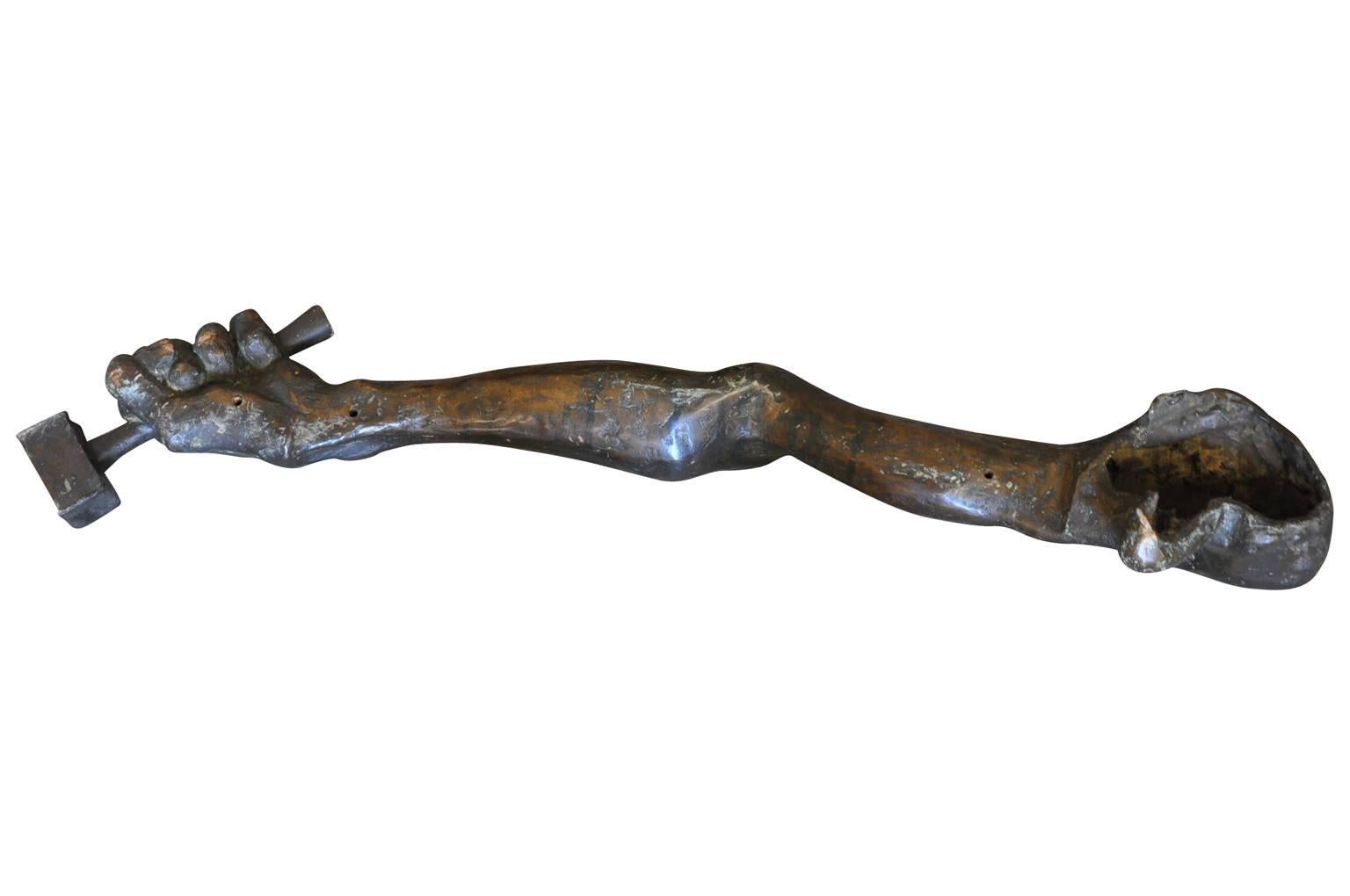 A sensational sculpture of a bronze arm and mallet from Naples, Italy. A terrific art piece to grace a table surface of bookcase. The are three small holes drilled on the back - where the piece was once mounted.