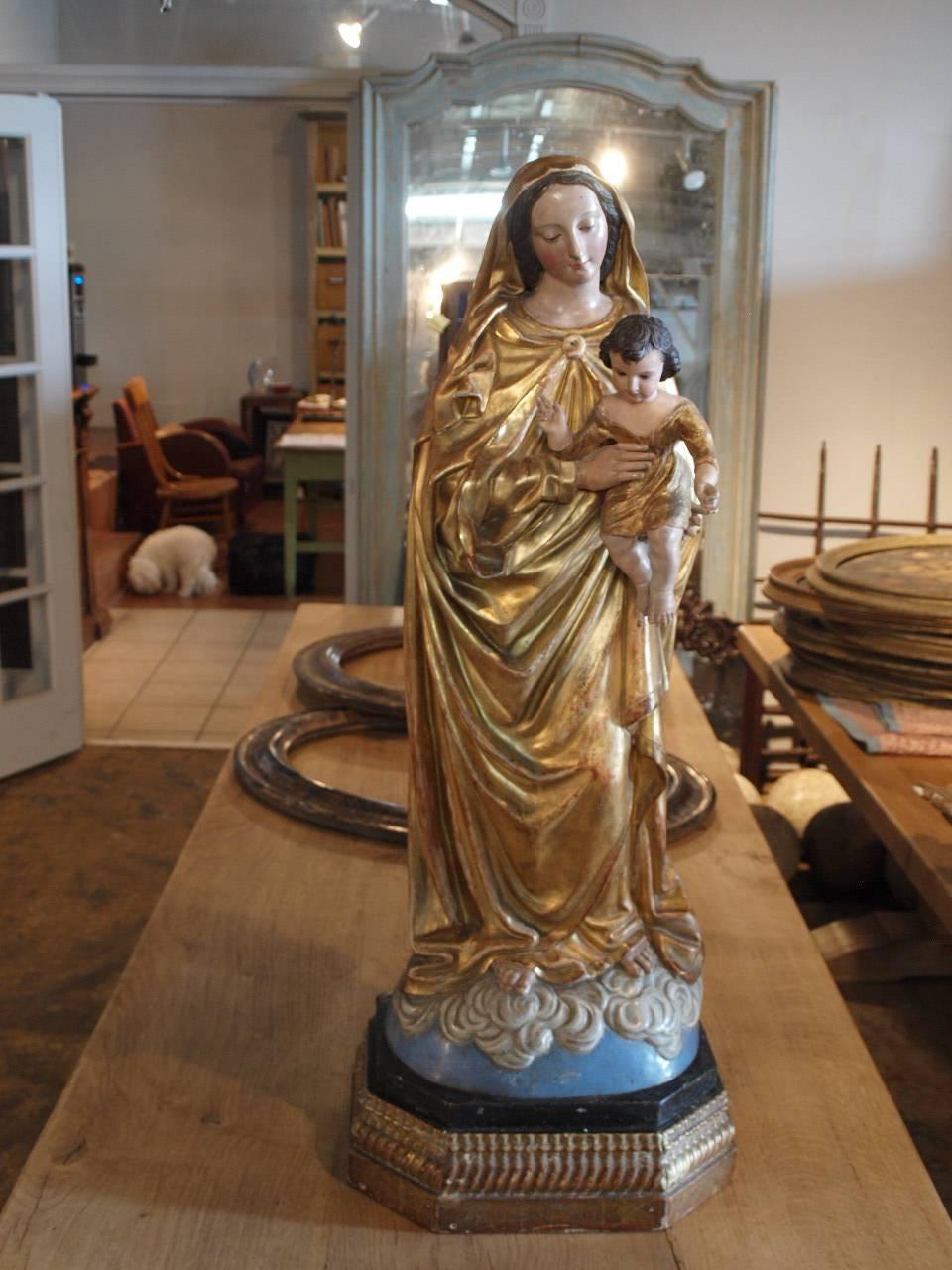 A very beautiful later 19th century statue of the Madonna and Child in polychromed and giltwood and papier mâché. Exquisite features and brilliant color.