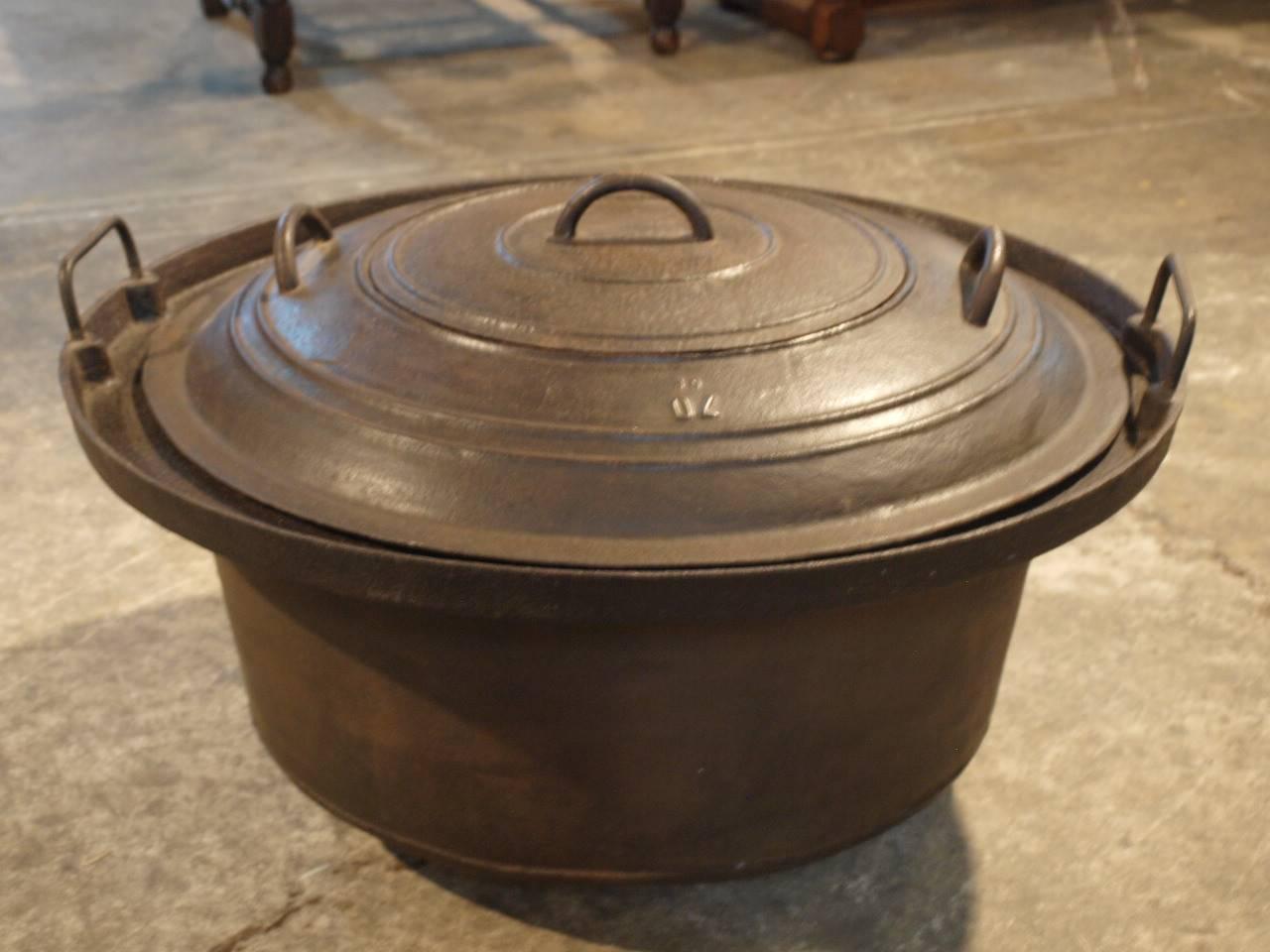 French mid 19th century cast iron pot with double lid.  Originally used as a duck scalding pot.  This piece will serve wonderfully as a fire pit or garden planter.