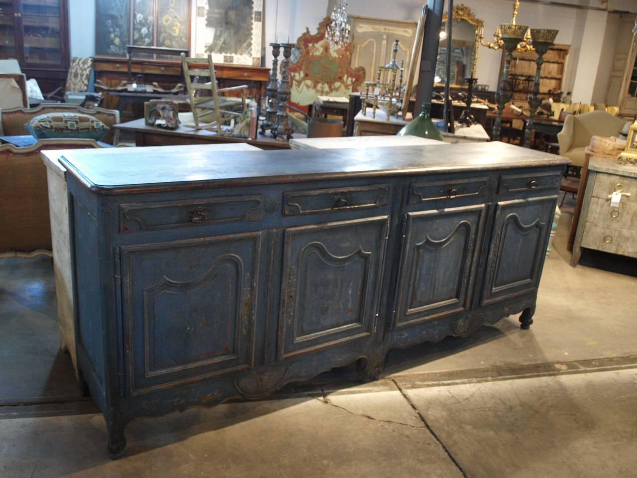A large scale French Provencal Enfilade - Buffet in painted wood.  Beautifully constructed with four drawers over four paneled doors.  Terrific patina and a wonderful painted finish.