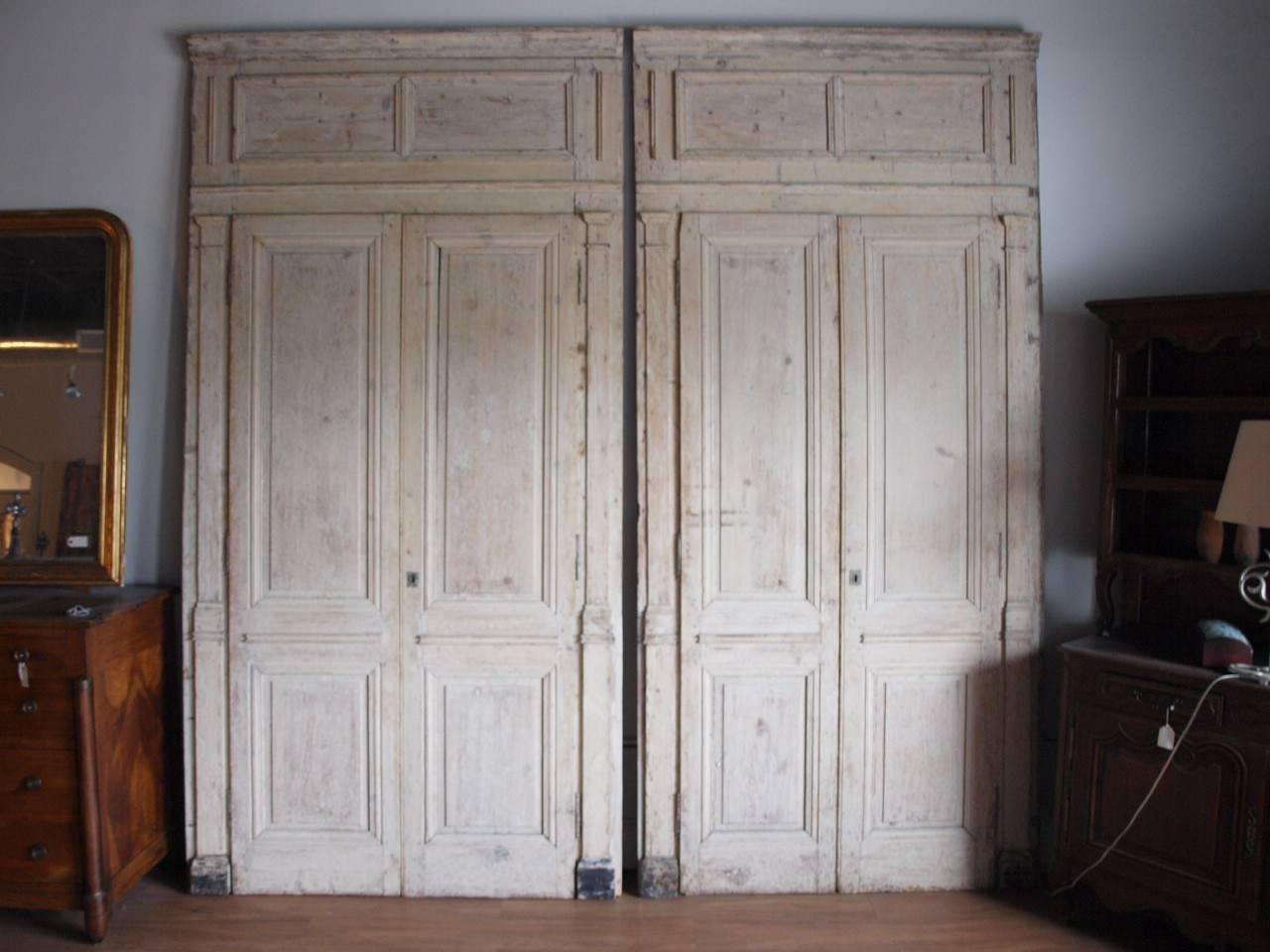A very handsome pair of early 19th century Directoire period boiseries door panels in painted pine wood, circa 1820. Wonderful to build in to enclose shelving or to install as doors. They are slightly different in size. One set measures: 121 1/2