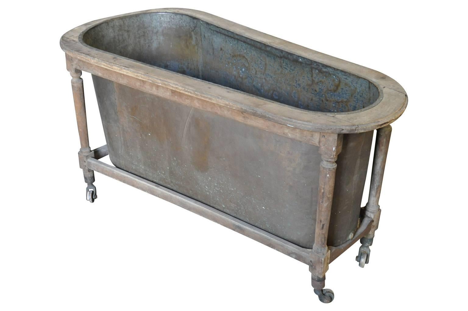 A delightful early 19th century French bathtub constructed from copper  in its walnut frame.  The tub is on metal casters.  A fabulous accessory for entertaining - wonderful to fill with ice and chill beverages!!