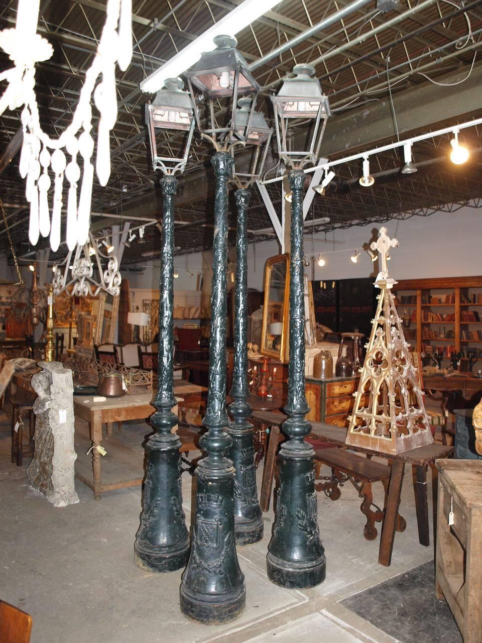 A tremendous set of four lamp posts / street lights from the Genoa area in Italy. Handsomely constructed in cast iron. The lanterns are in copper and bronze. The base of the post is decorated with a family crest and crown and the upper post is