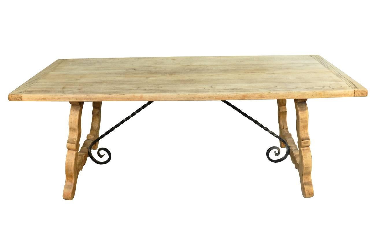 A wonderful farm table - trestle table in washed or bleached oak with iron stretchers from the southwest of France. Not only does this table serve as a terrific dining table, but as a writing table or sofa table as well.