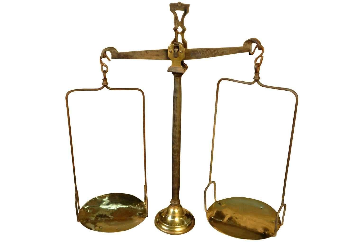 A handsome French 18th century balance scale in iron and brass. The balance mechanism is in iron. The foot and the plates are in brass. The foot of the shaft and one of the plates display the maker's hallmarks. The scale is a lovely decorative piece