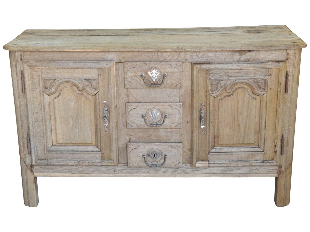 A very handsome French Louis XIV style buffet in bleached or washed oak. Beautifully constructed with two doors and three drawers. A great serving piece or to place a flat screen television above.