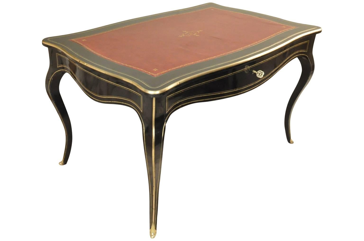 A stunning and very fine 19th century French Napoleon III bureau plat - writing desk. Masterfully constructed in ebonized or lacquered wood, with bronze mounts. The top is inset with a gilt tooled leather writing surface and molded edges. The apron