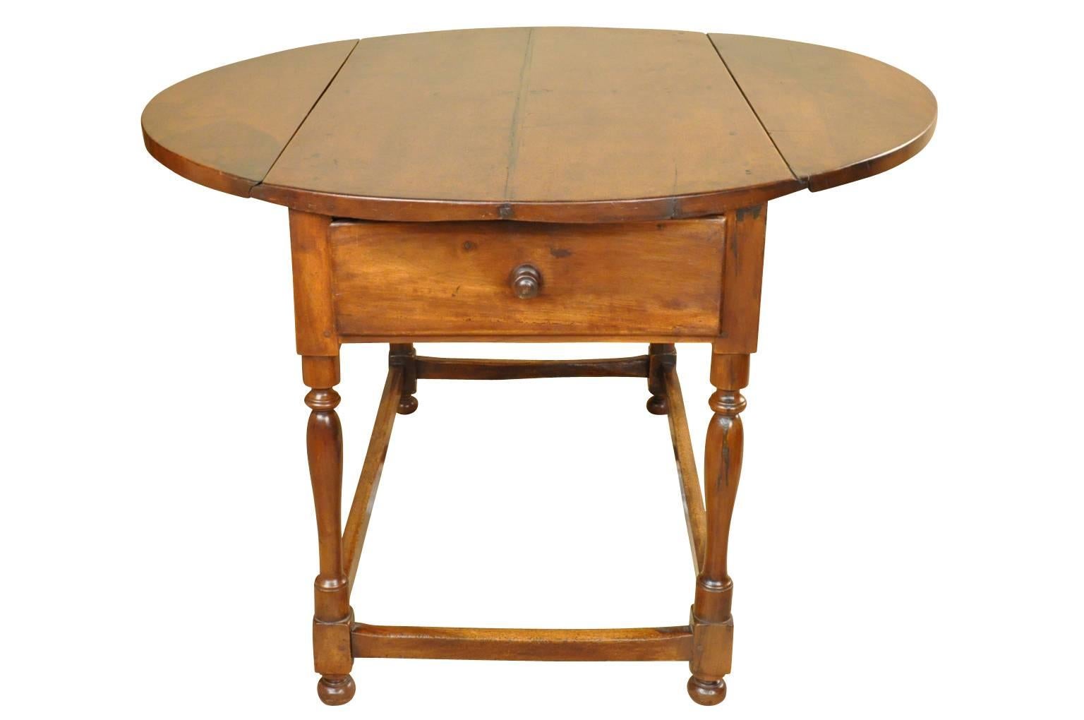 A very handsome 18th century oval shaped drop-leaf table from the Provence region of France. Wonderfully constructed with lovely turned legs and two drawers. The top surface is constructed with thick planks. All in solid walnut. The graining and