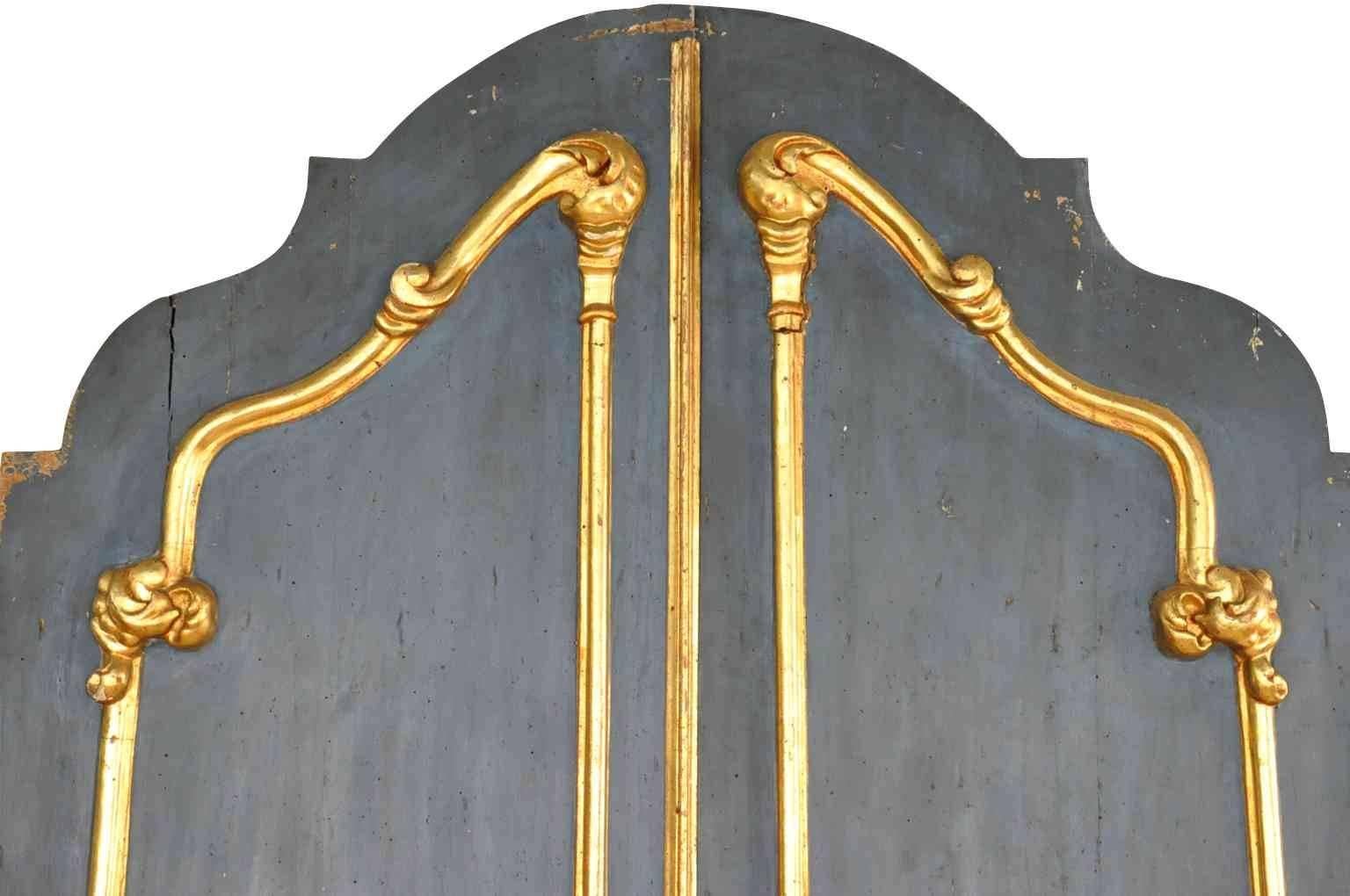 A sensational pair of Italian 18th century doors in gilt and polychromed wood. Beautifully shaped with a sculpted arch. The rich and vibrant blue color is so inviting. A fabulous architectural accent to lend elegance and charm.