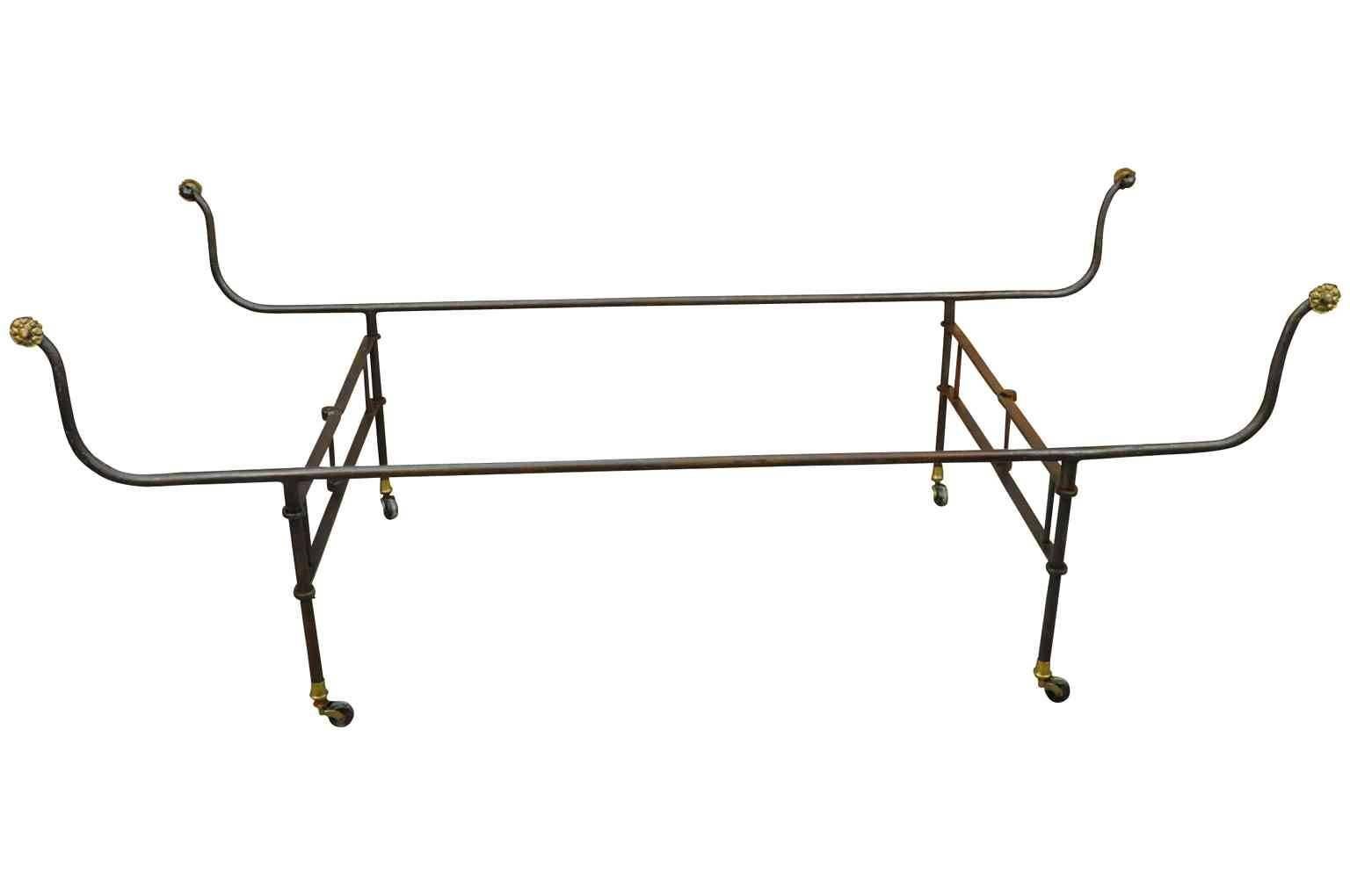 A very rare 19th century French collapsible Campaign bed in hand-forged iron with bronze medallions - on casters. This piece offers such versatility. Not only can it be used as a daybed, but collapsed in a narrower position, the piece can be