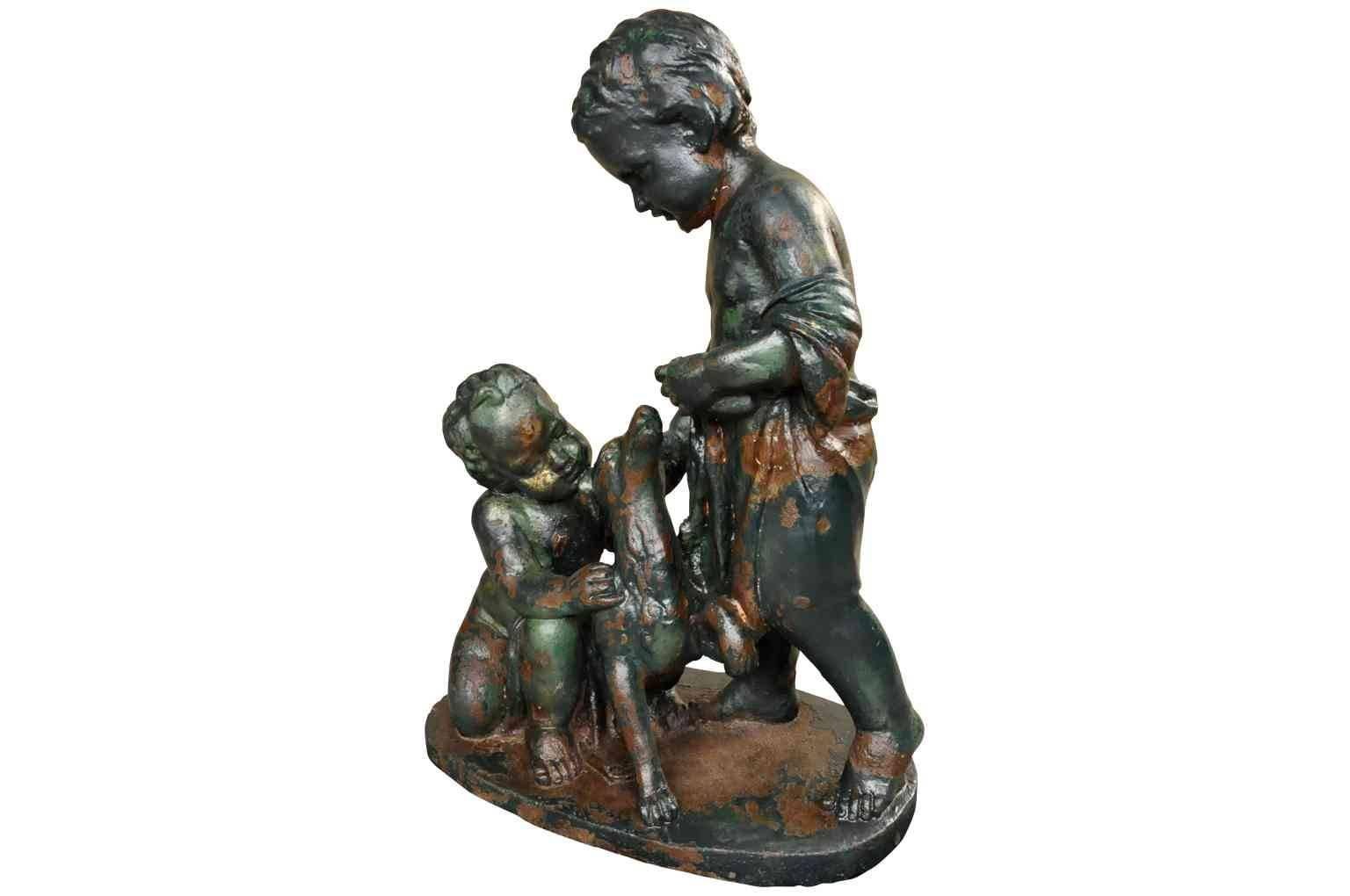 A very charming 19th century French figural statue in painted cast iron. A sweet motif of two children playing with their pet dog. Wonderful as a garden accessory or as an interior decoration.