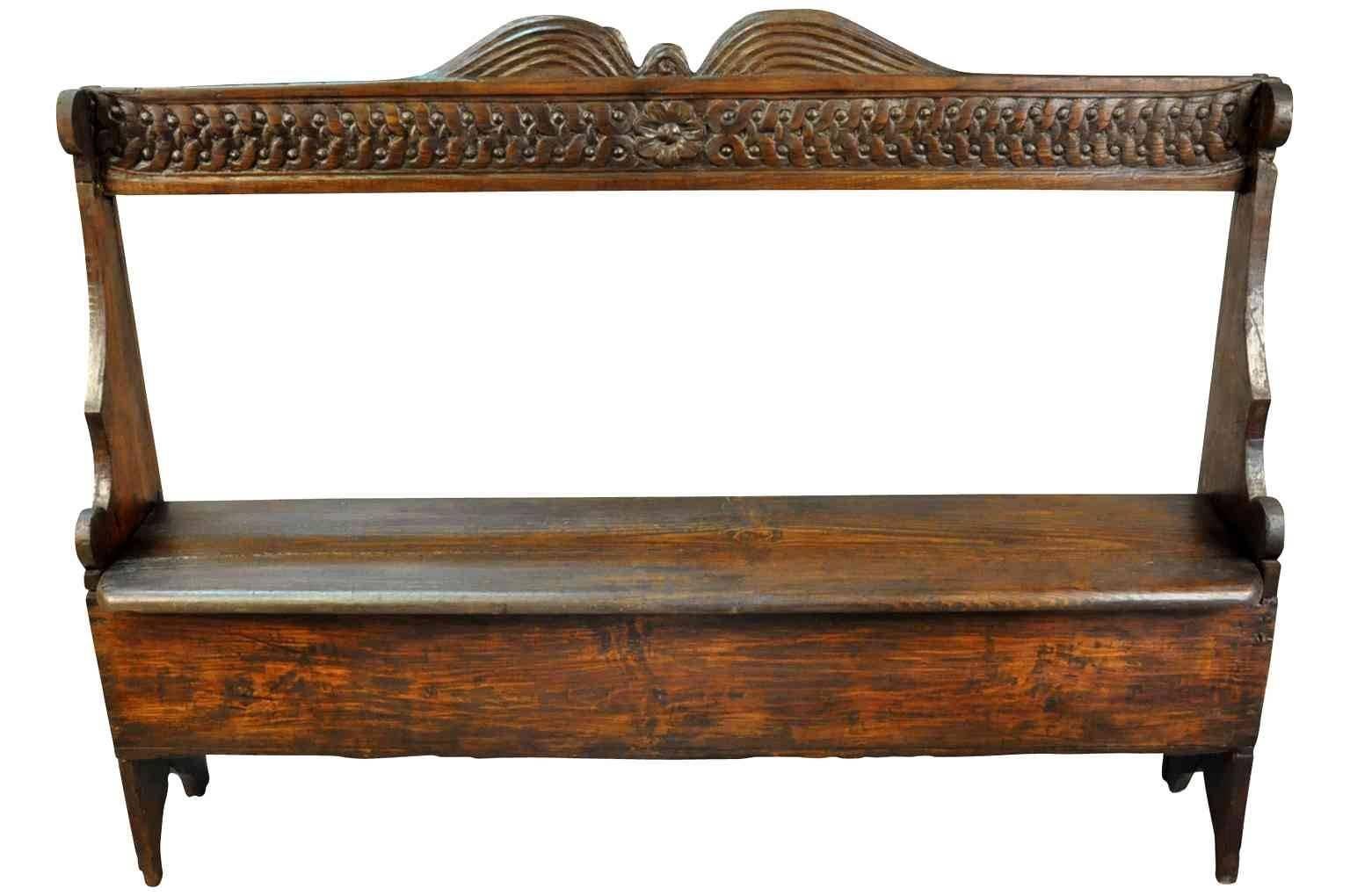 A charming early 19th century settle bench from Portugal. The seat lifts to expose a storage area. Wonderful for a keeping room or mud room.