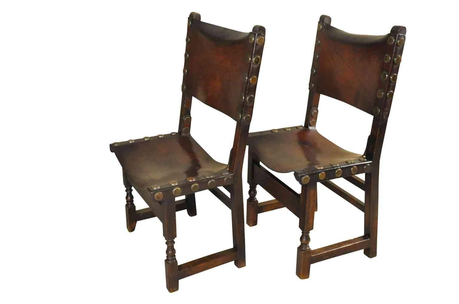 A very handsome pair of 17th century Spanish chairs in walnut and leather. Wonderful nail heads adorn the beautifully patinated leather. Very sound and sturdy.