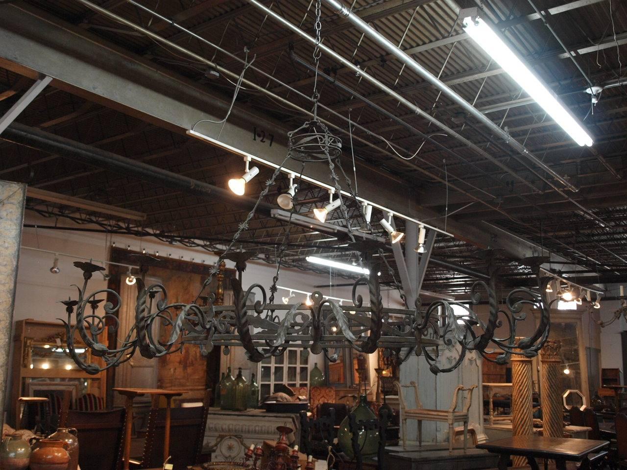 An outstanding and monumental pair of early 19th century chandeliers from Northern Italy. These exceptional 16-arm fixtures are expertly crafted in forged iron with scrolling acanthus leaves and stunning chains. Please note the hand written conto-or