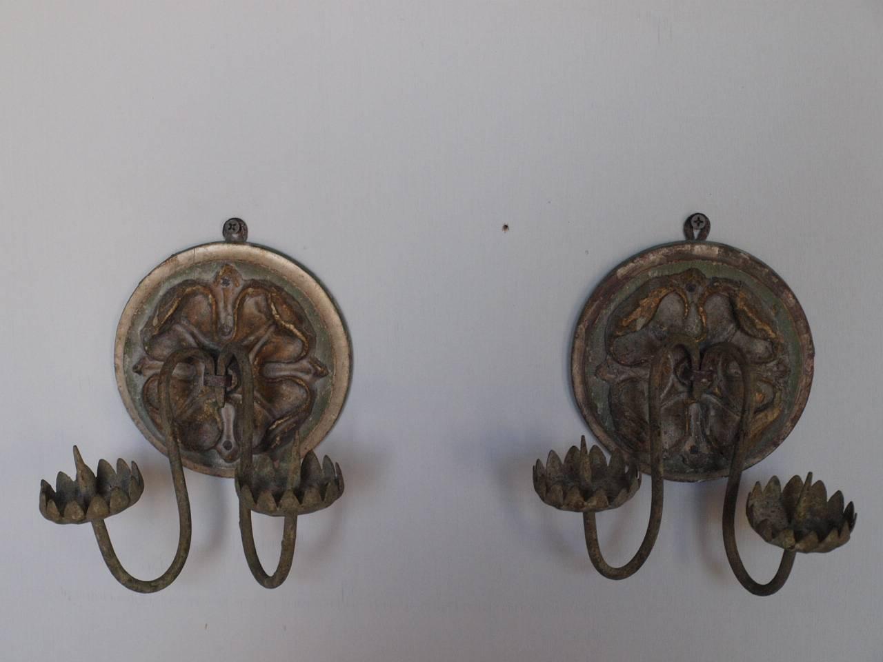 A very beautiful pair of 18th century sconces, appliques from Northern Italy. Beautifully constructed from silver giltwood, papier-mâché medallions and hand-forged iron. Understated and elegant. The back disk measures 5 1/4 in diameter.