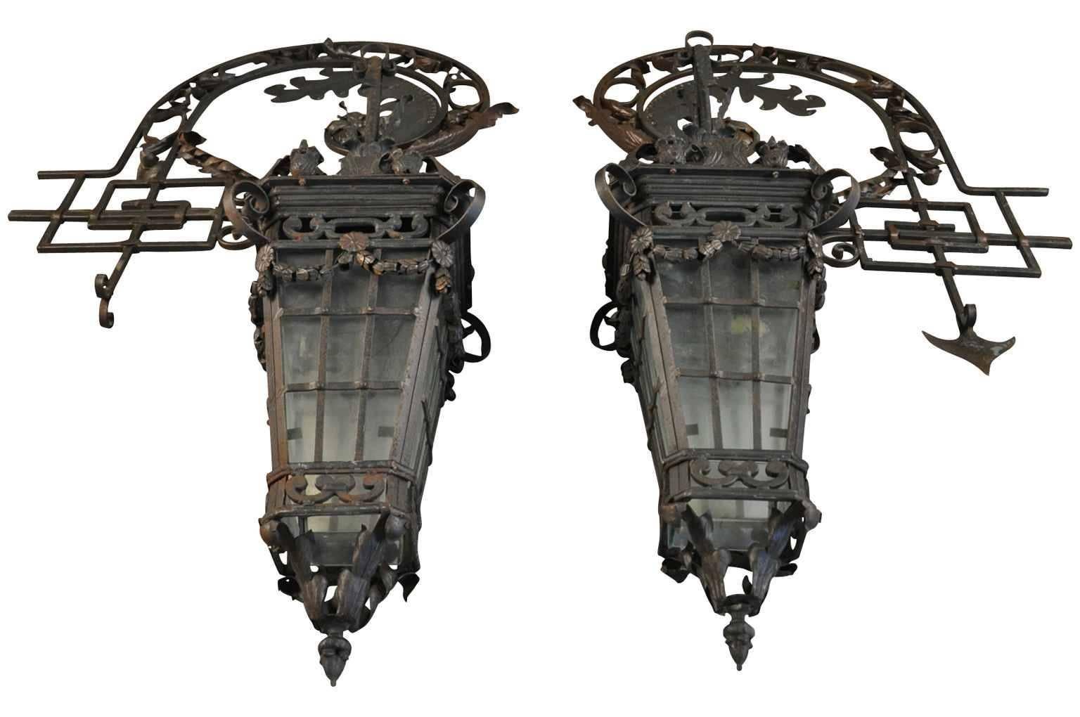 Monumental pair of French wrought iron lanterns with their original wall brackets. A stunning statement for a grand entry.
