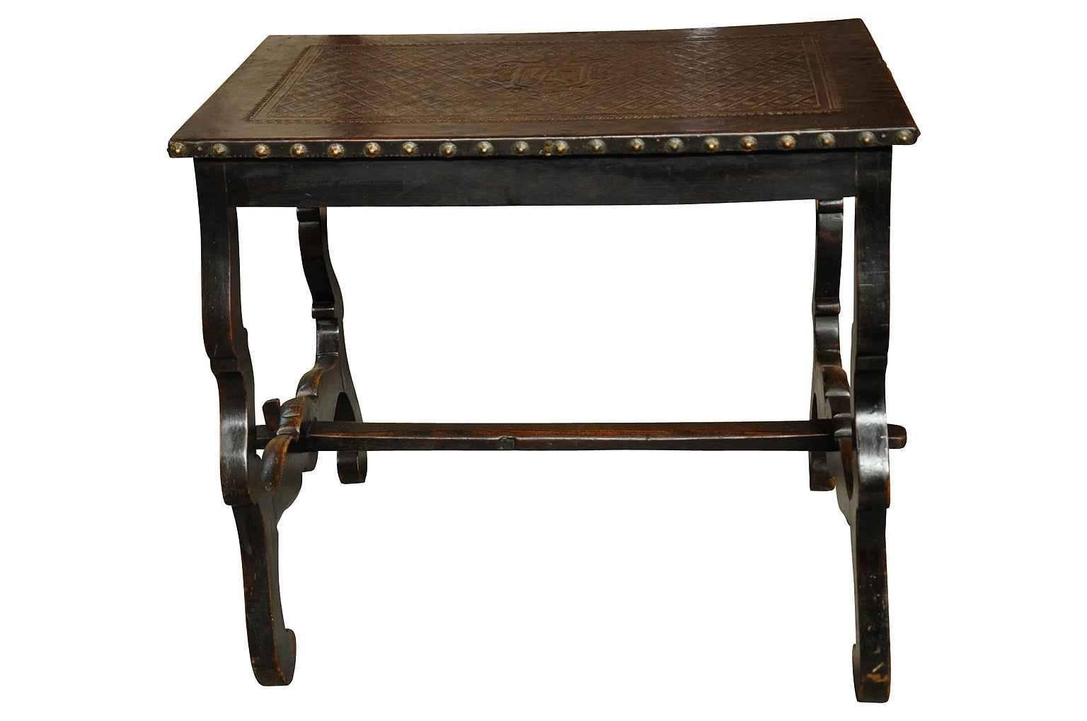 A very intriguing early 19th century side table from the Catalan region of Spain. Wonderfully constructed from walnut with classical lyre shaped legs. The top is enveloped in hand tooled leather, presenting a Blasson, family crest or coat of arms.