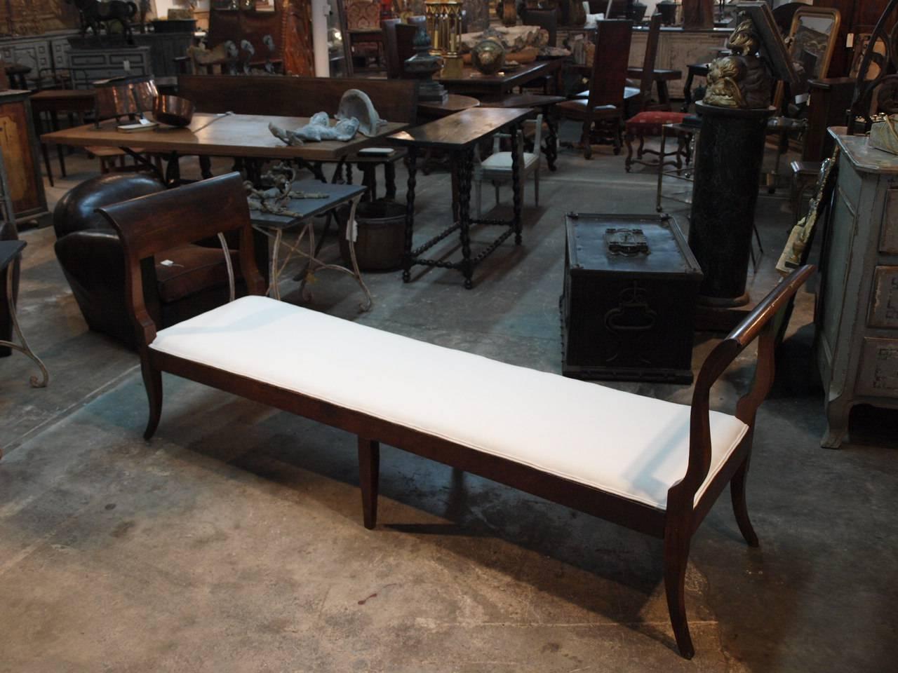 A very lovely and elegant 19th century Banquette from Bologna, Italy. Handsomely constructed in chestnut with clean and Minimalist lines. Newly reupholstered. Measures: 18
