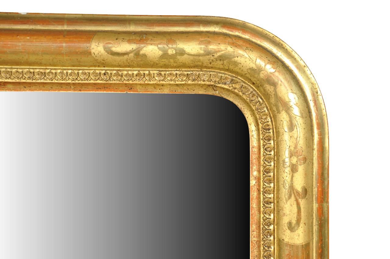 A very attractive mid-19th century Louis Philippe period mirror from France. Crafted from giltwood and retaining its original mercury glass. The exposed reddish bole adds handsome depth to the mirror. The back is lined with wood to protect the glass.