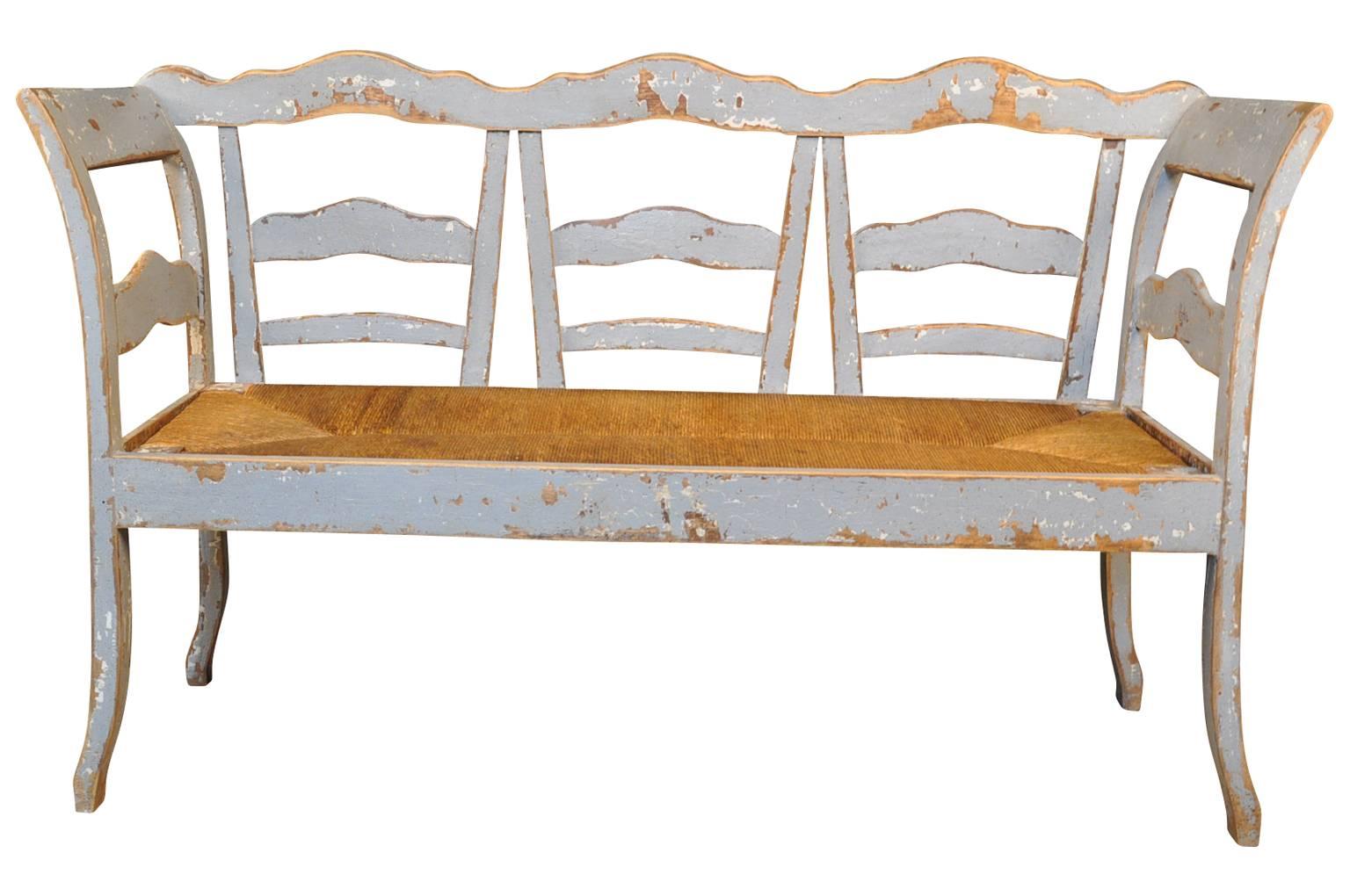 A delightful late 19th century painted bench with rush seat from the Catalan region of Spain.