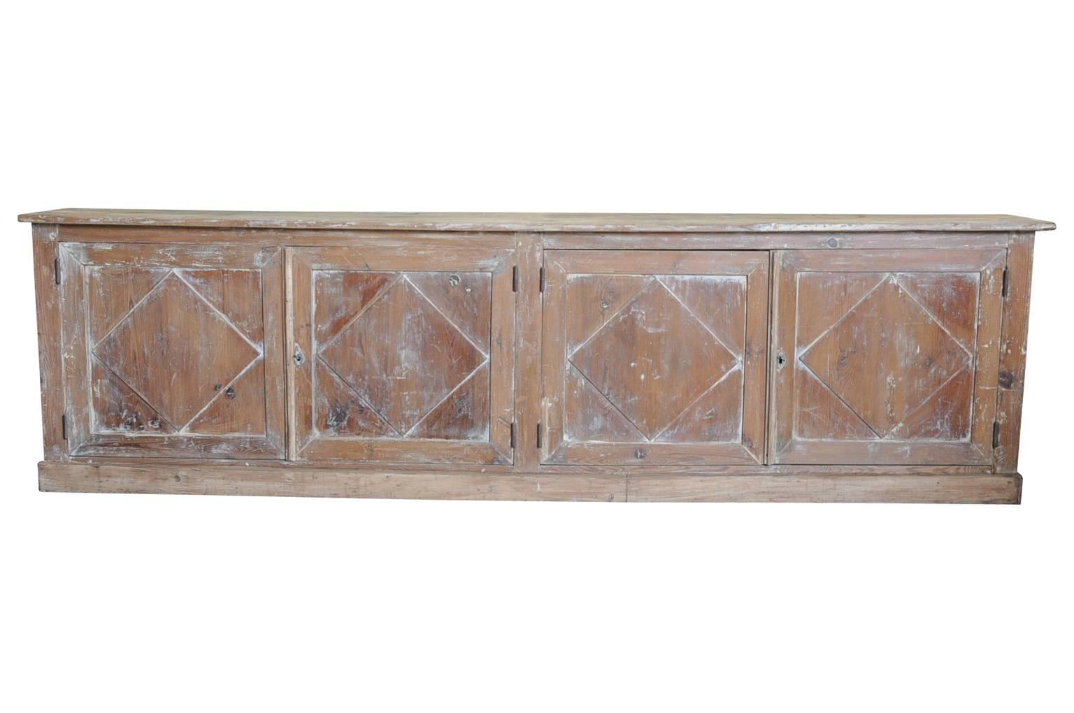 A very beautiful early 19th century buffet enfilade from the South of France. Soundly constructed in washed bleached wood with four doors. Nice narrow depth considering the length of the piece. A terrific storage piece.