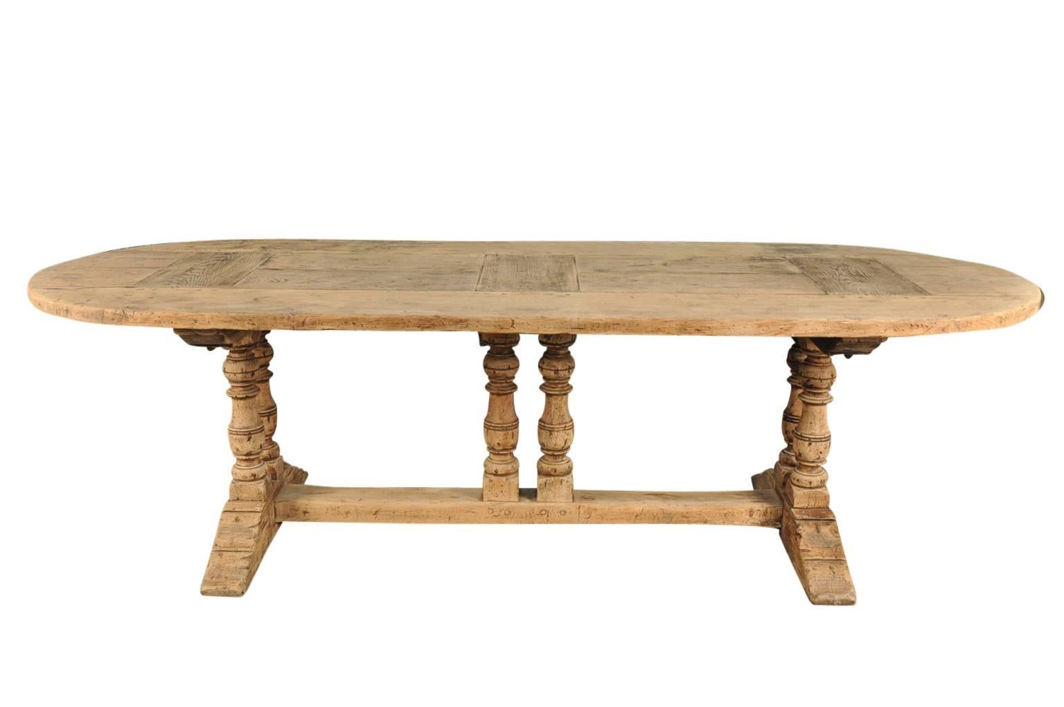 A very charming oval shaped French balustre leg farm table trestle table. Soundly constructed from washed bleached oak with lovely 