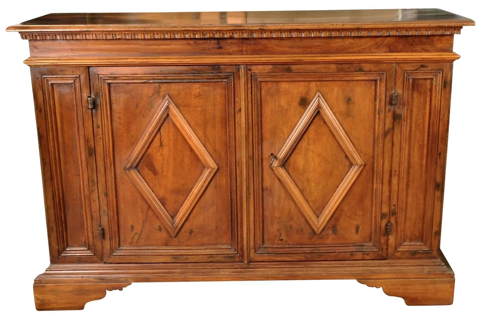 A very handsome early 19th century walnut Credenza from the Bologna region of Italy. Handsomely constructed with raised lozenge panel doors, dentilated detail and raised on bracket feet.