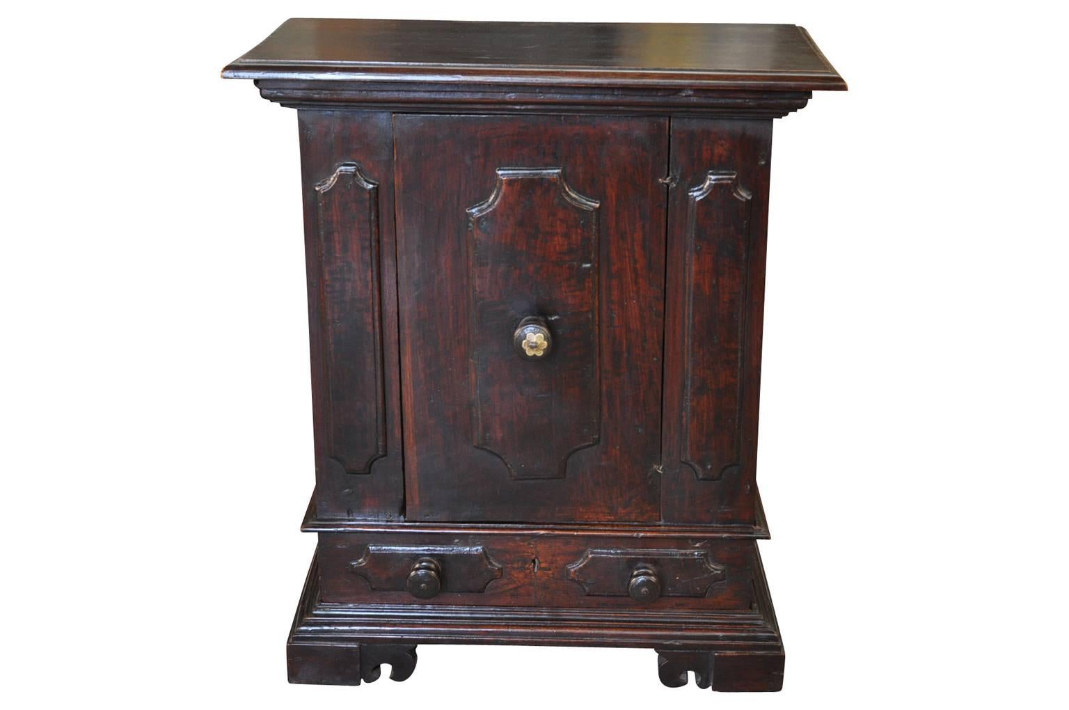 A lovely early 19th century small credenza - credenzino from Northern Italy. Handsomely crafted from walnut with one-door and one-drawer raised on bracket feet.