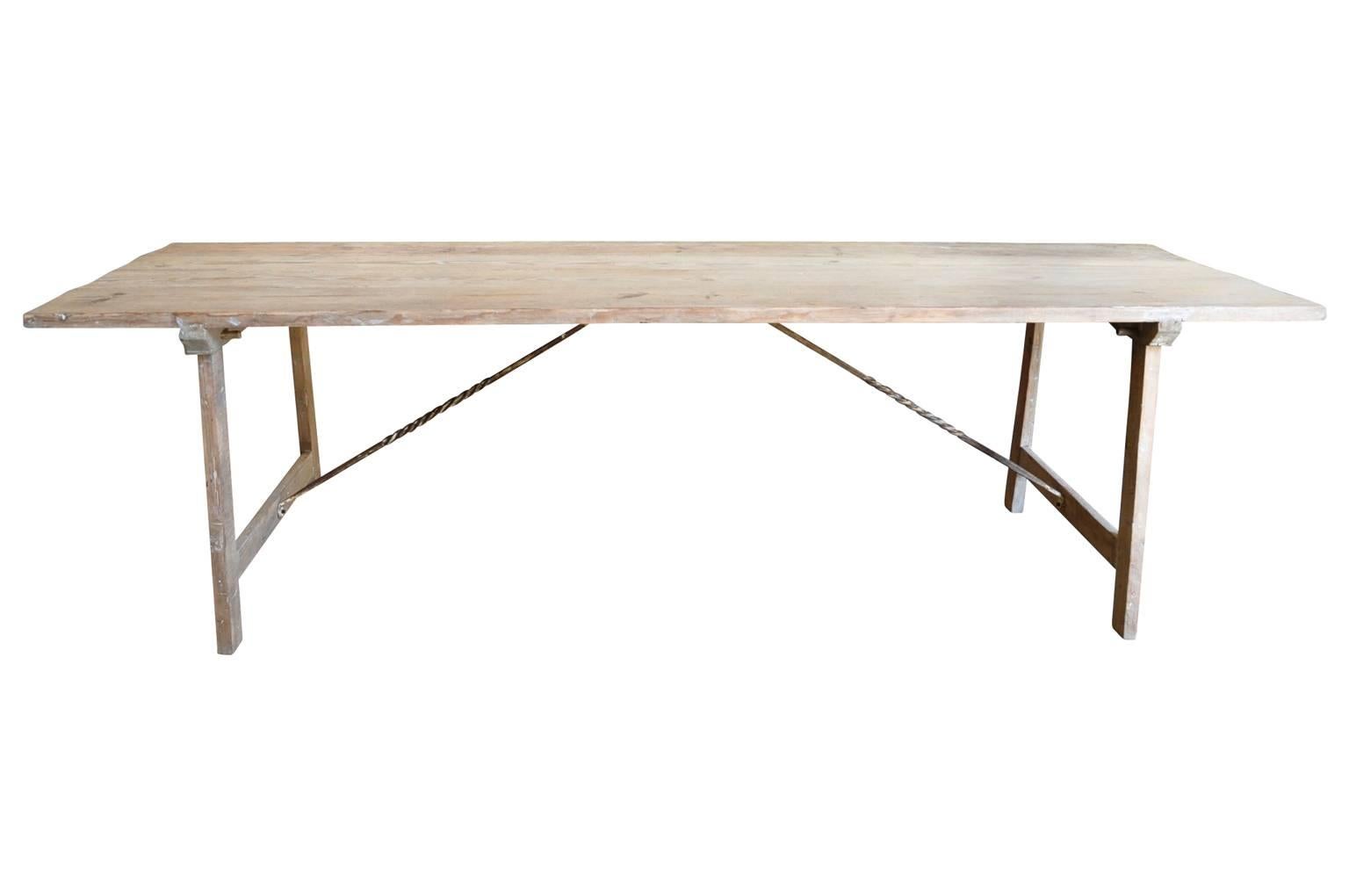 A mid-19th century farm table from Majorca, Spain. Soundly constructed from pinewood and hand-forged iron stretchers.